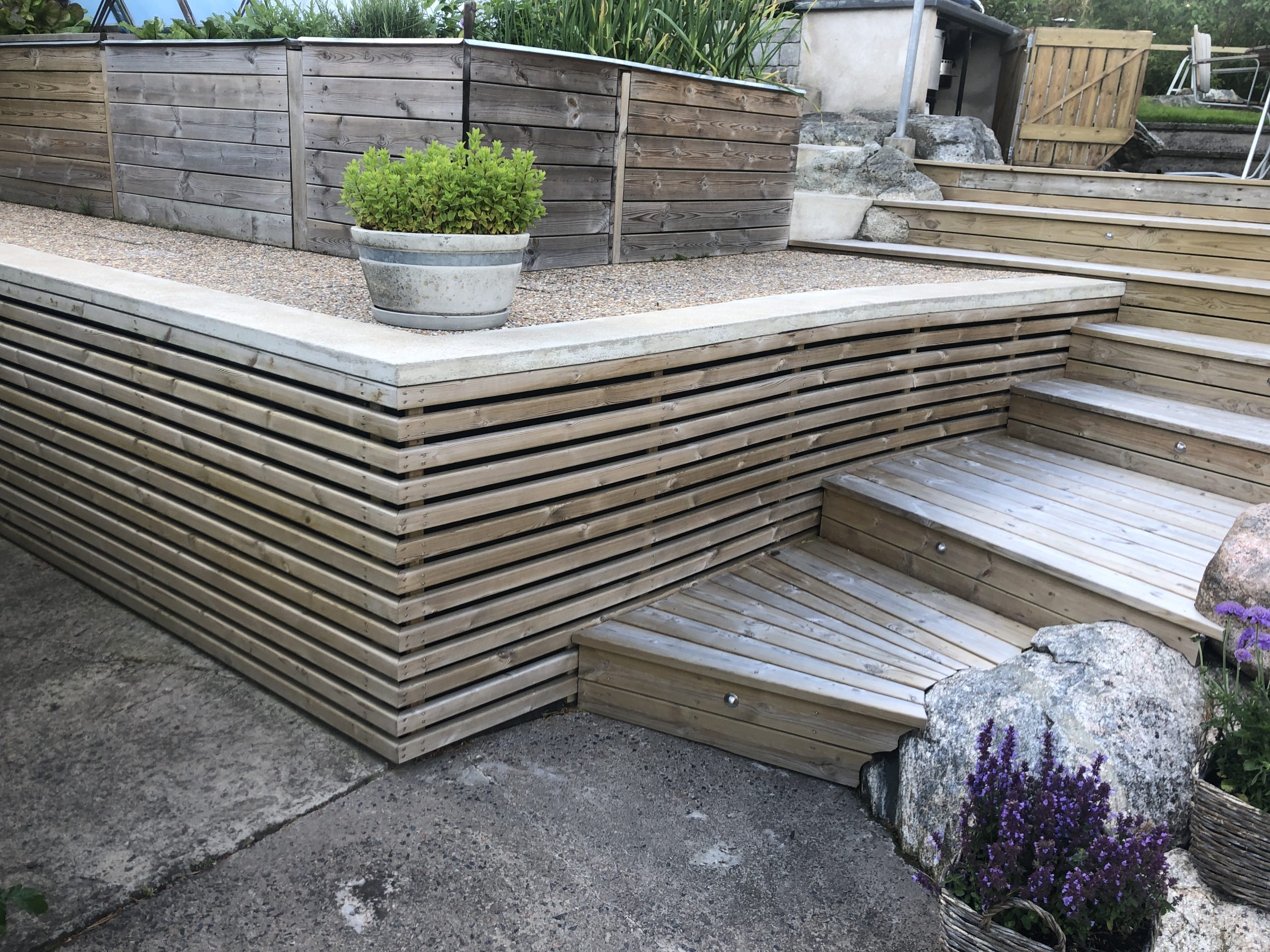 Träterrass med flera nivåer i trädgårdshörnet