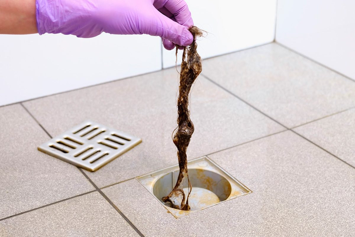 Golvbrunn igensatt av hår och smuts