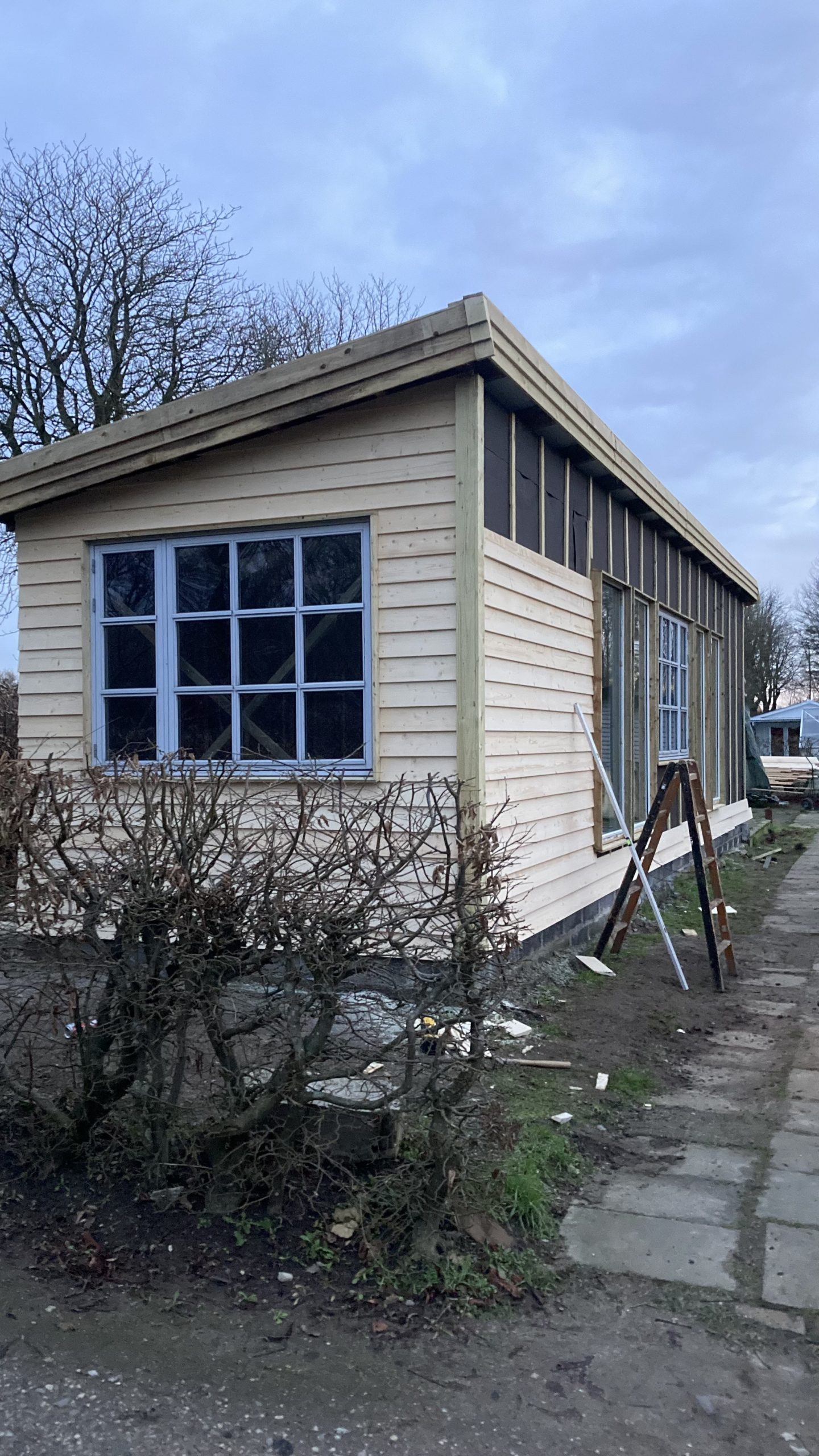 Anneks med genbrugsvinduer og klinkbeklædning