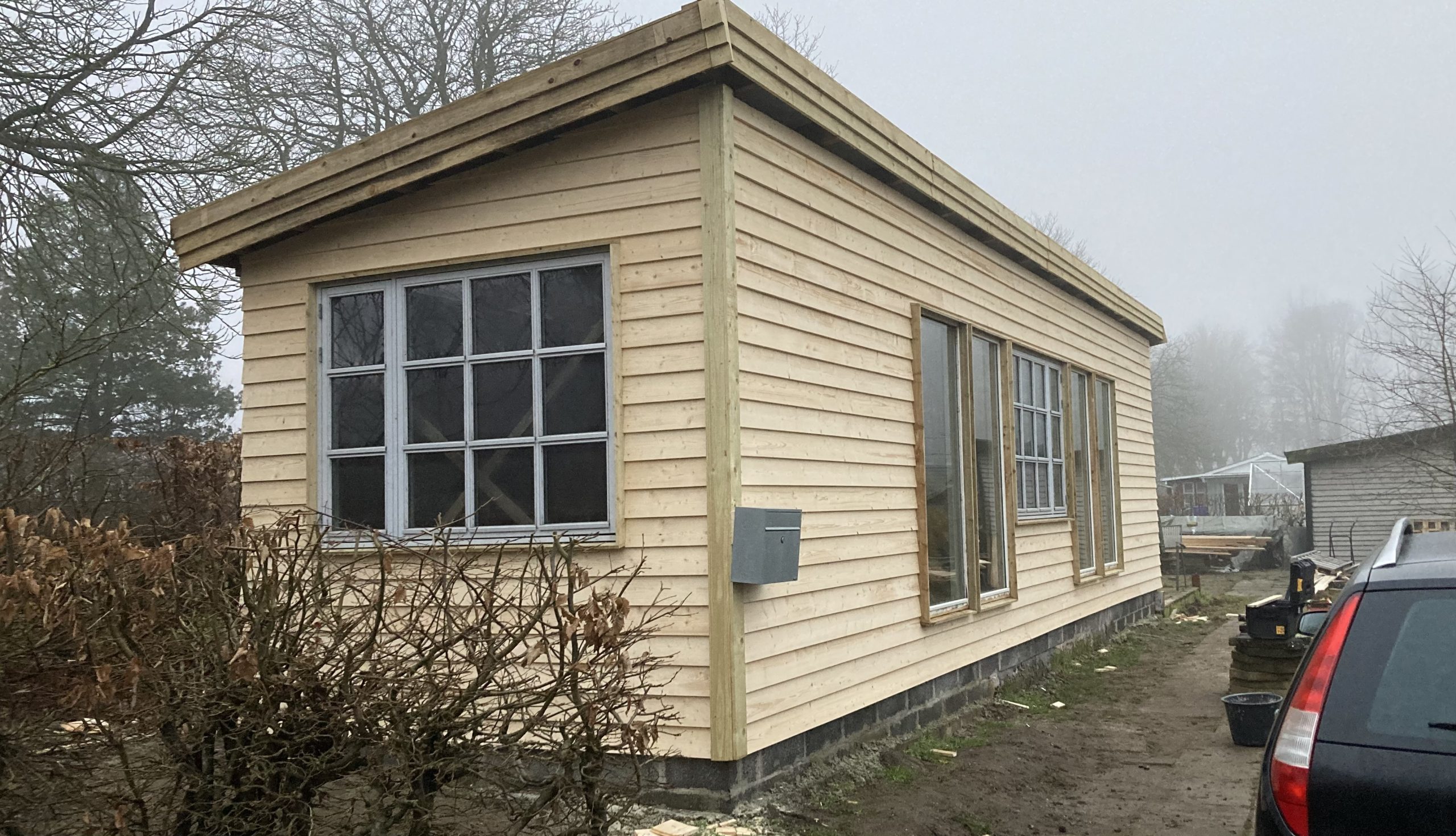 Anneks med genbrugsvinduer og klinkbeklædning