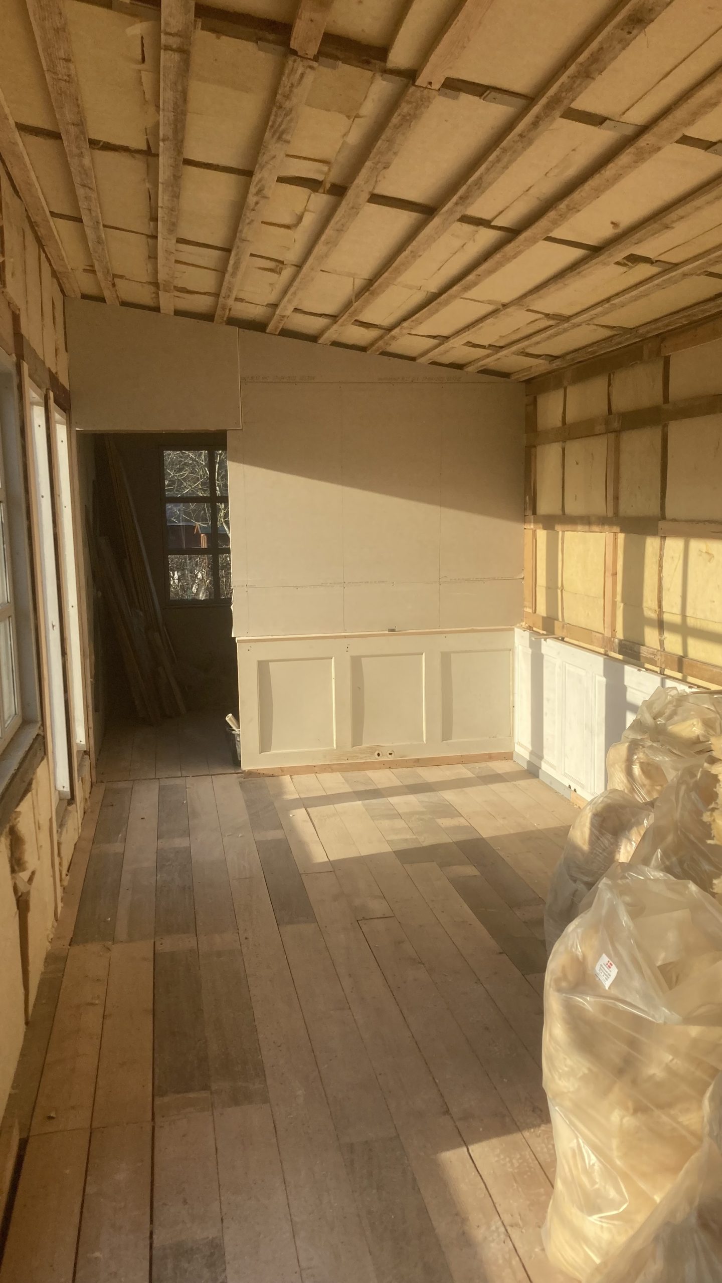 Anneks med genbrugsvinduer og klinkbeklædning