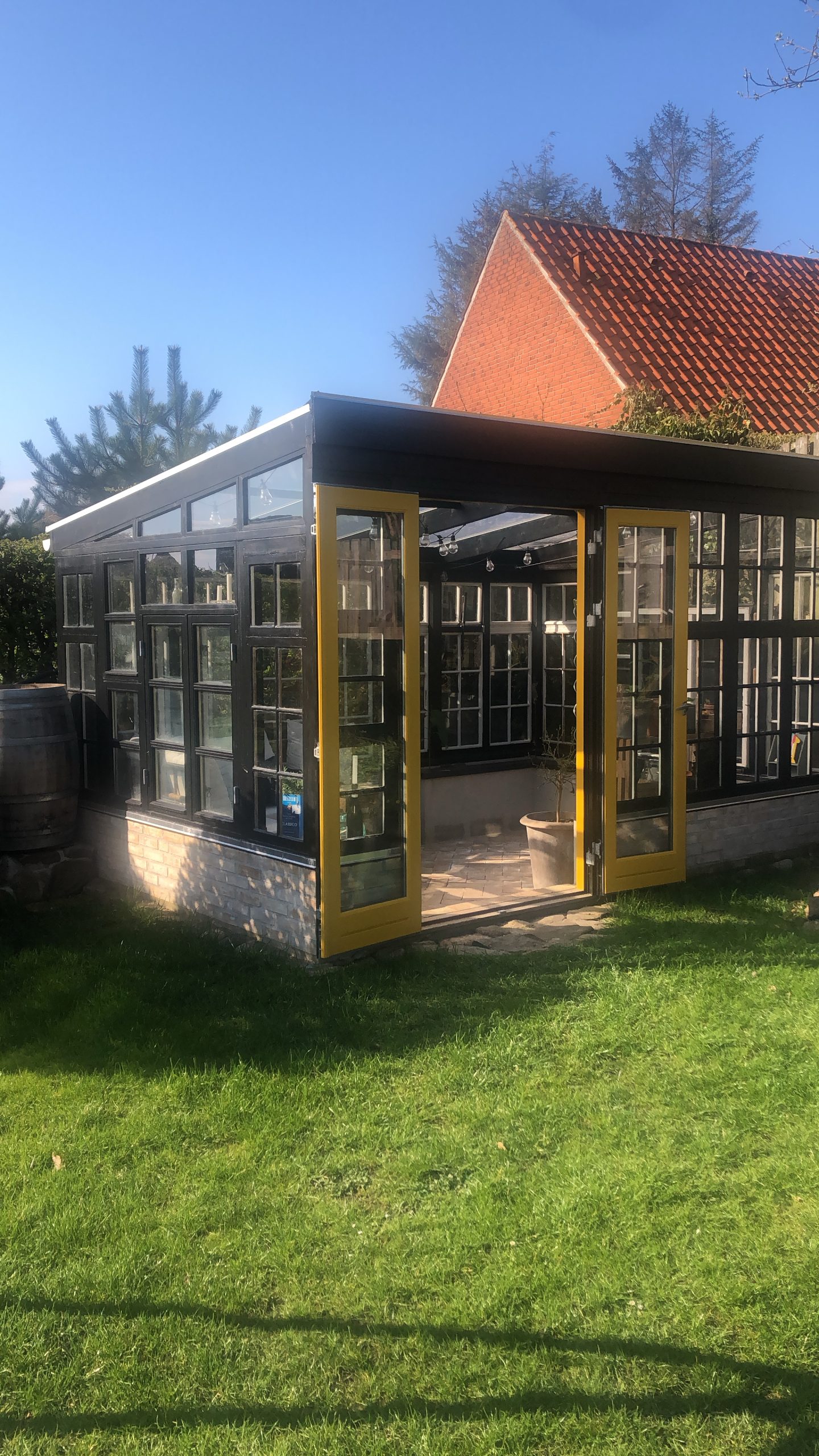 Orangeri av återvunna tegelstenar, dörrar och fönster