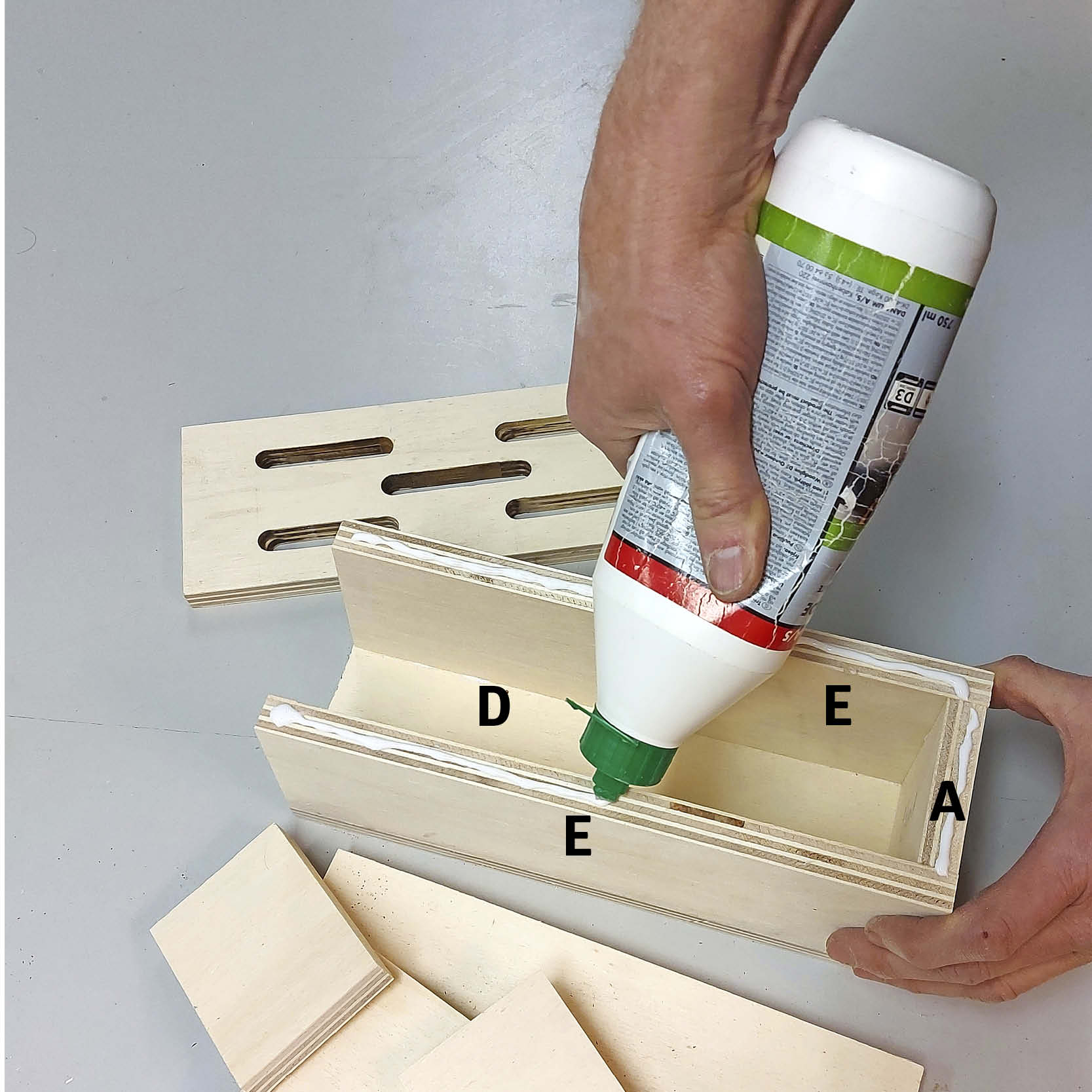 Perhoshotellin pihalle: Liimaa ja naulaa etuseinä kiinni.