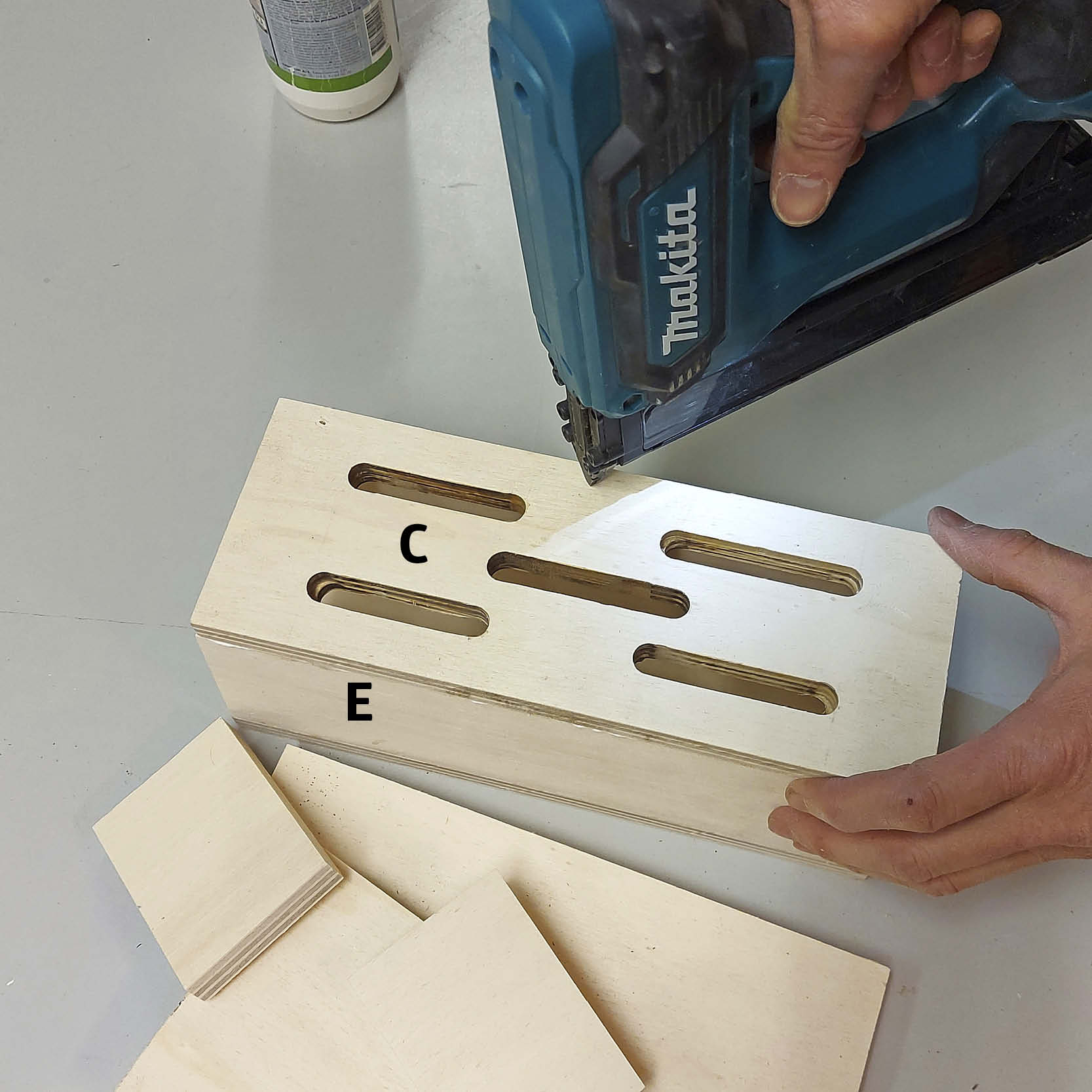 Perhoshotellin pihalle: Liimaa ja naulaa etuseinä kiinni.