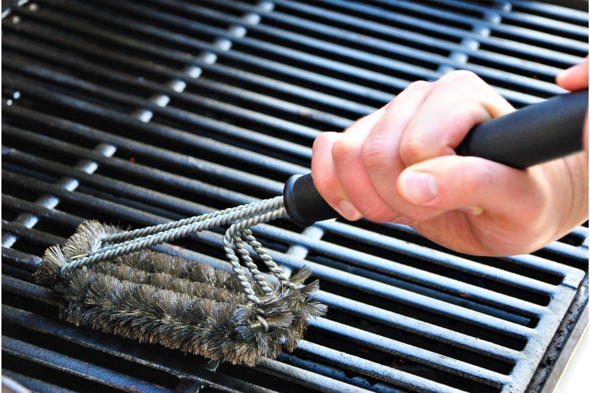 Rengøring af grillrist med grillbørste.