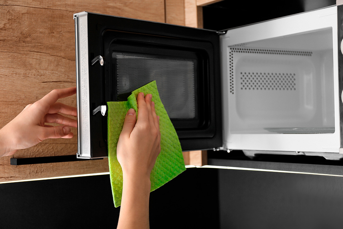 Rengjøring av mikrobølgeovn med en mikrofiberklut