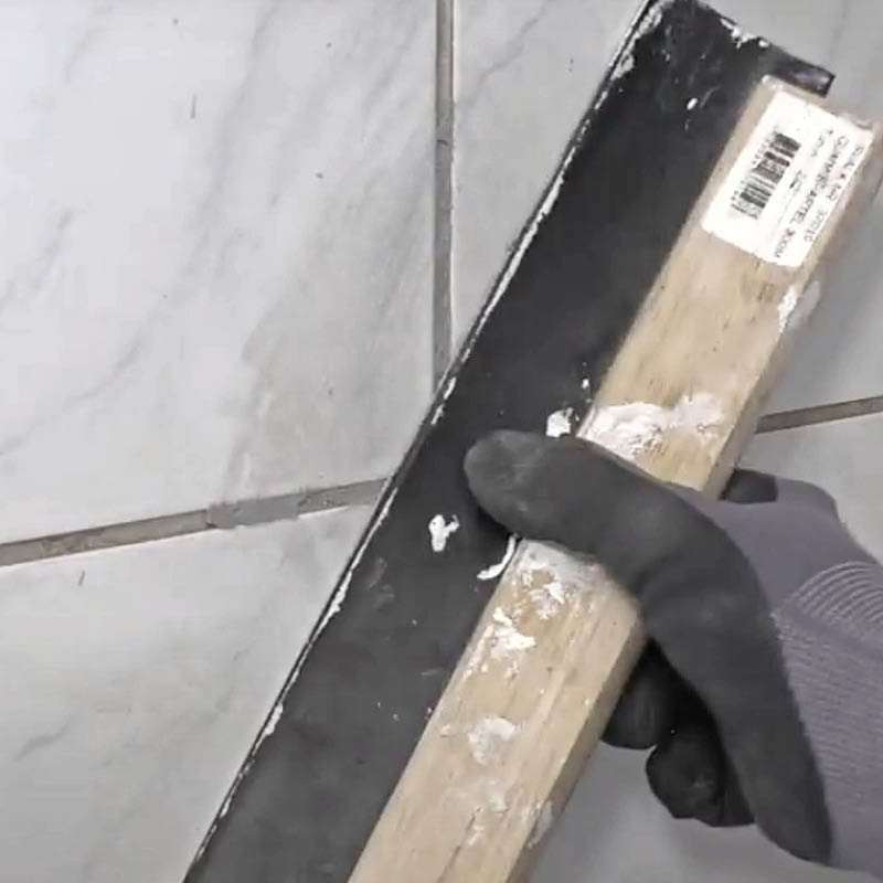 Huller i flisefugen: Træk den overskydende fugemasse af med en gummispartel