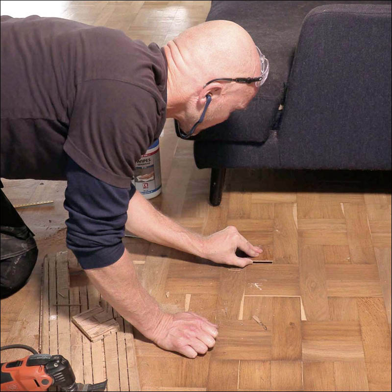 Puuttuva vanerinpala parkettilattiassa: Pane palanen reikään