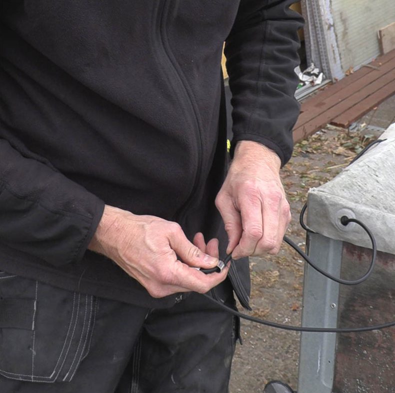 Peräkärryn peite: Työnnä kuminauha molempien vaijerilukkojen läpi