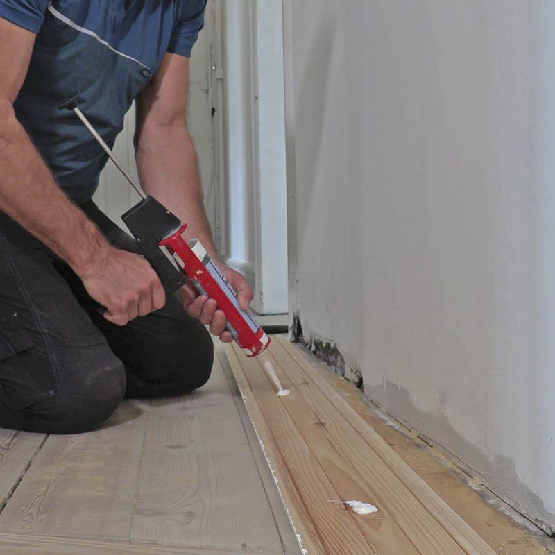 Irronnut jalkalista: Levitä asennusliimaa listan ja seinän väliin