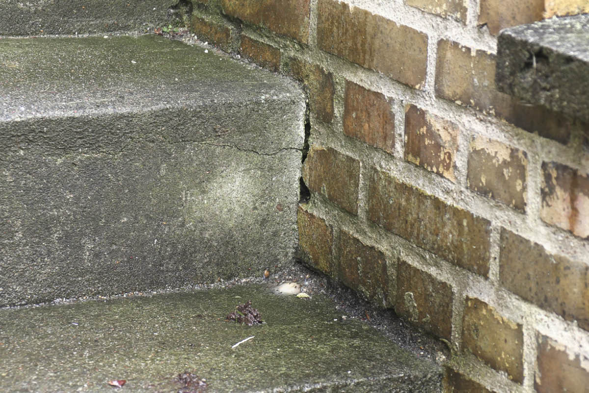 Sprickor mellan trappa och vägg utomhus