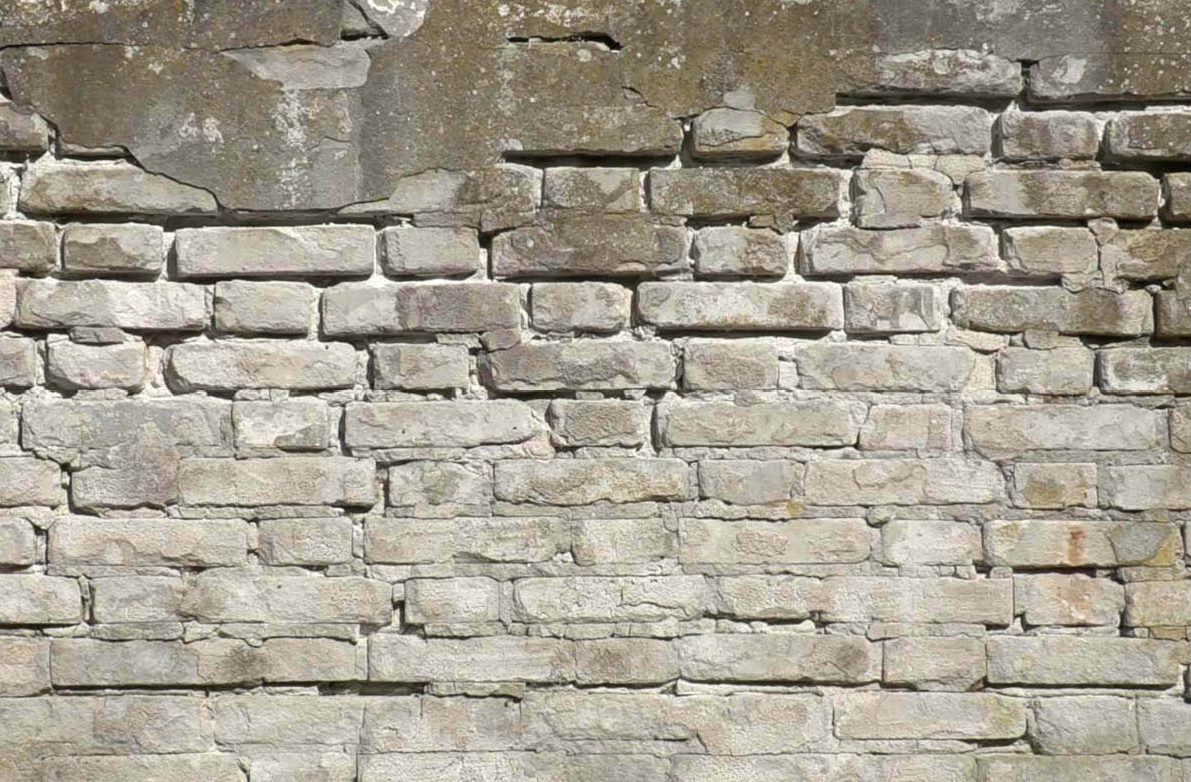 Vägg med skadad puts och lösa fogar