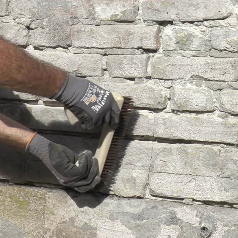 Mur med ødelagt puss og løse fuger: Børst hardt med en stålbørste