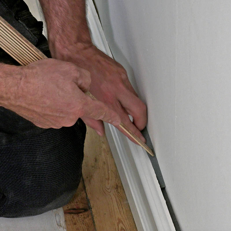 Iso rako seinän ja jalkalistan välissä: Asenna saumanauha tasaisesti