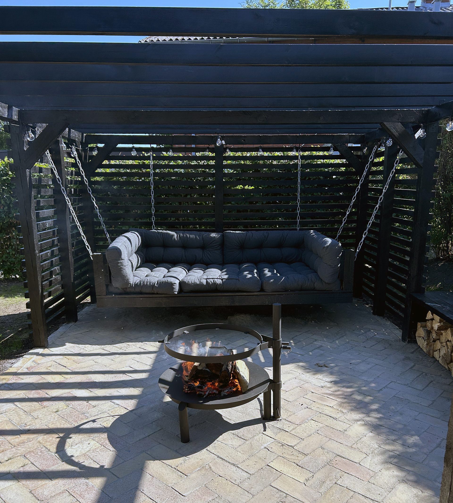 Pergola med hængesofa og bålsted