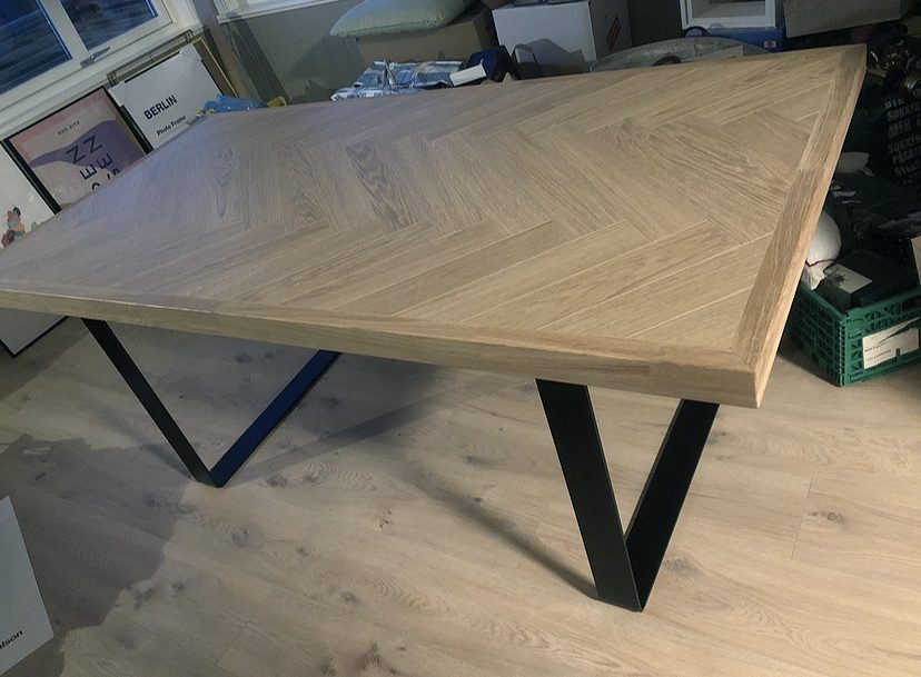 Robust spisebord af laminatgulv lagt i sildeben