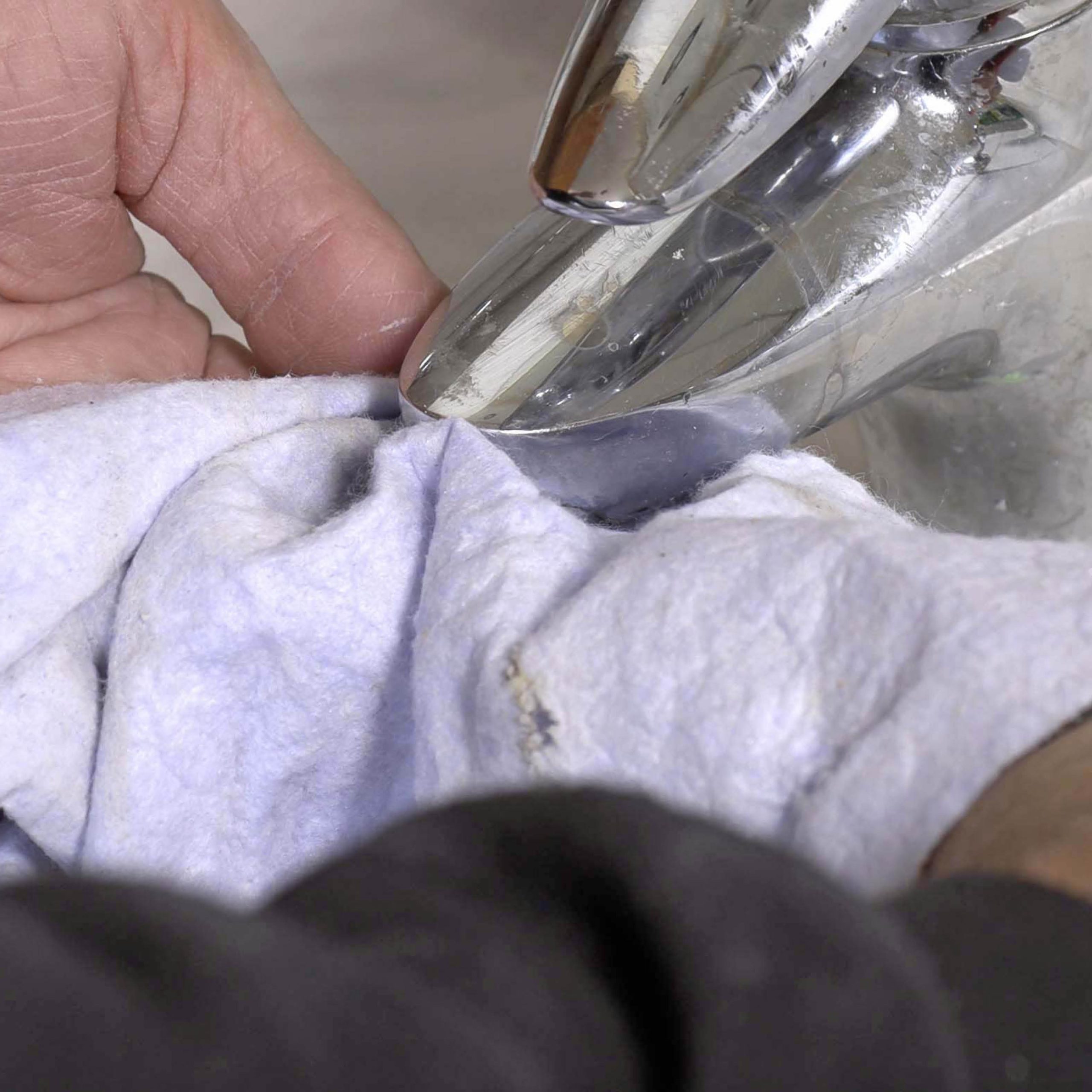 Hvordan fjerne kalk fra kran: Legg en klut mellom kranen og tangen