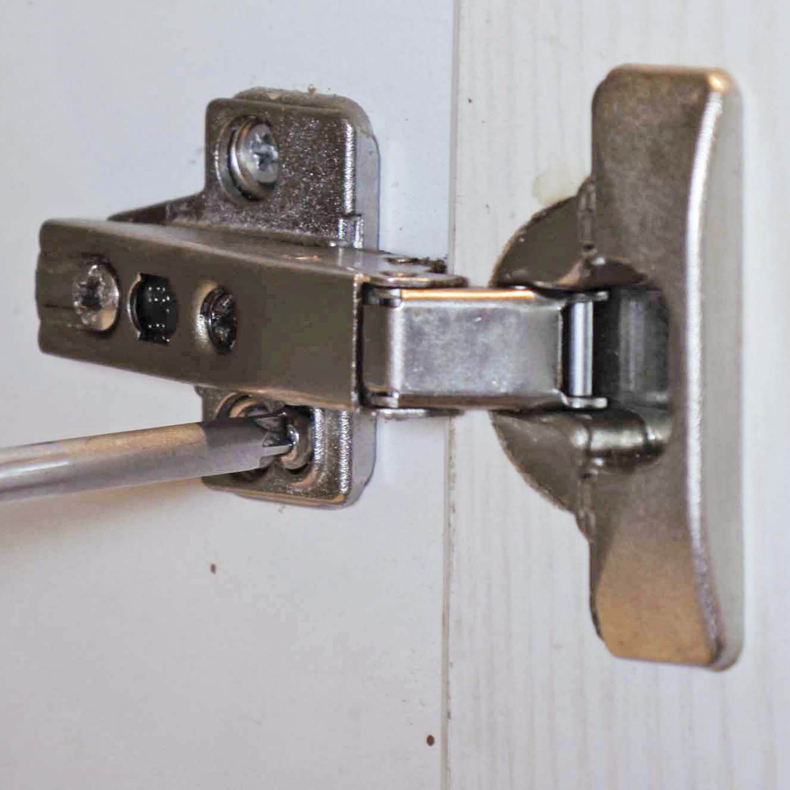 Justere køkkenlåge: Løsn de skruer, der holder beslaget fast i skabssiden