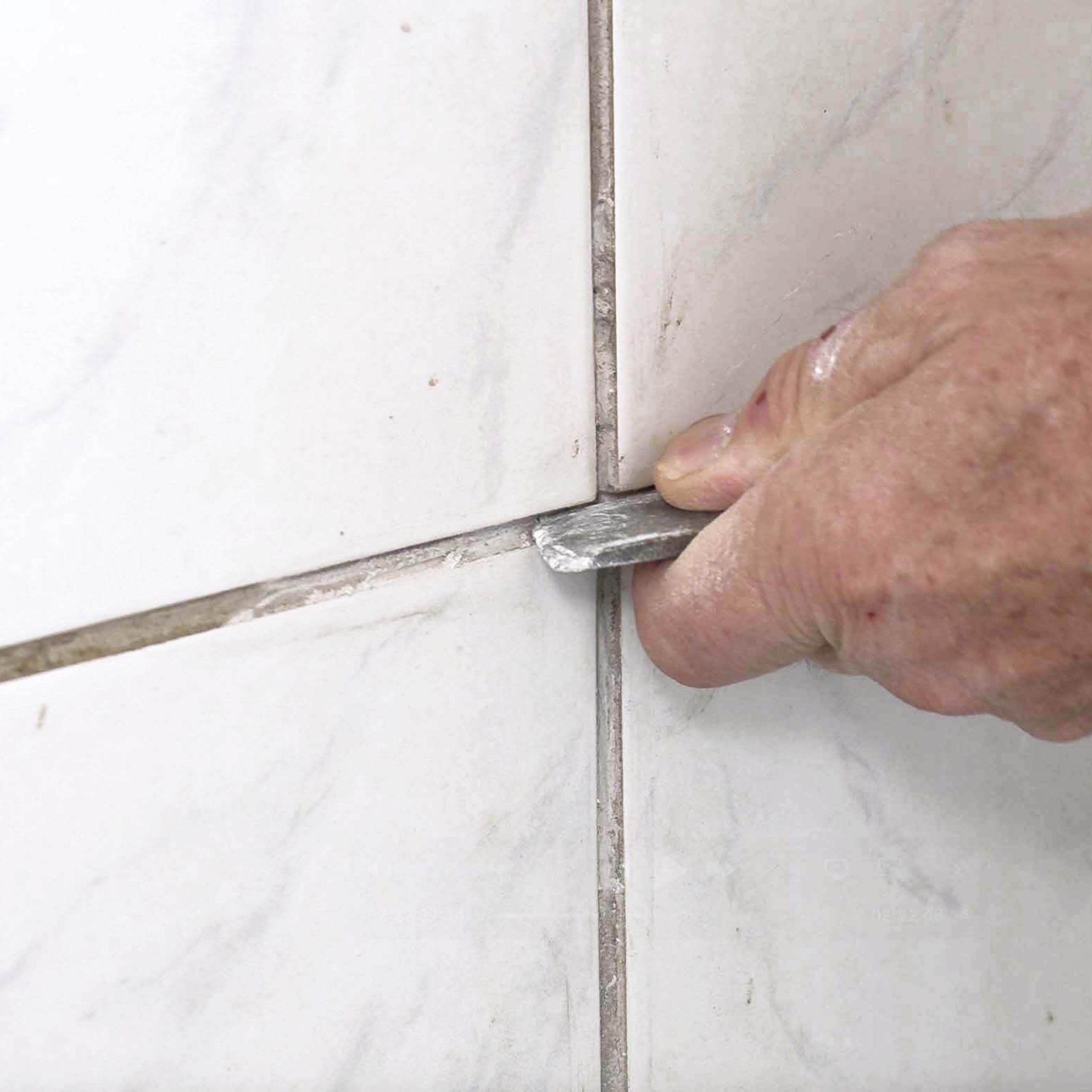 Huller i flisefugen: Krads de sidste fugerester ud med en mejsel