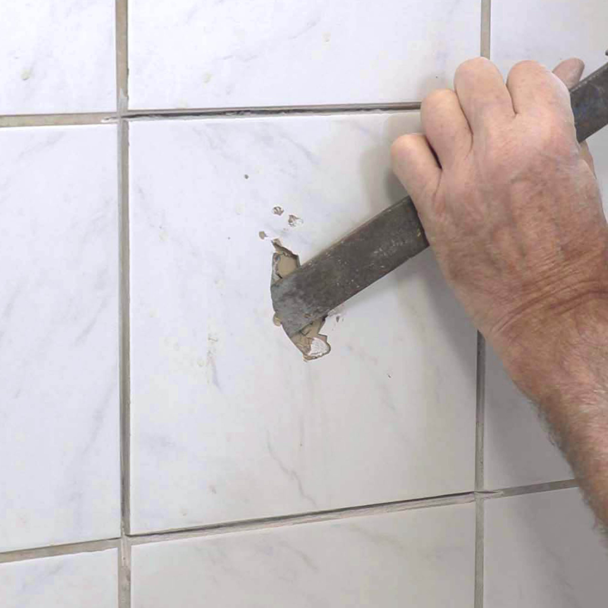 Skade i vægflise: Slå flisen i stykker med hammer og mejsel