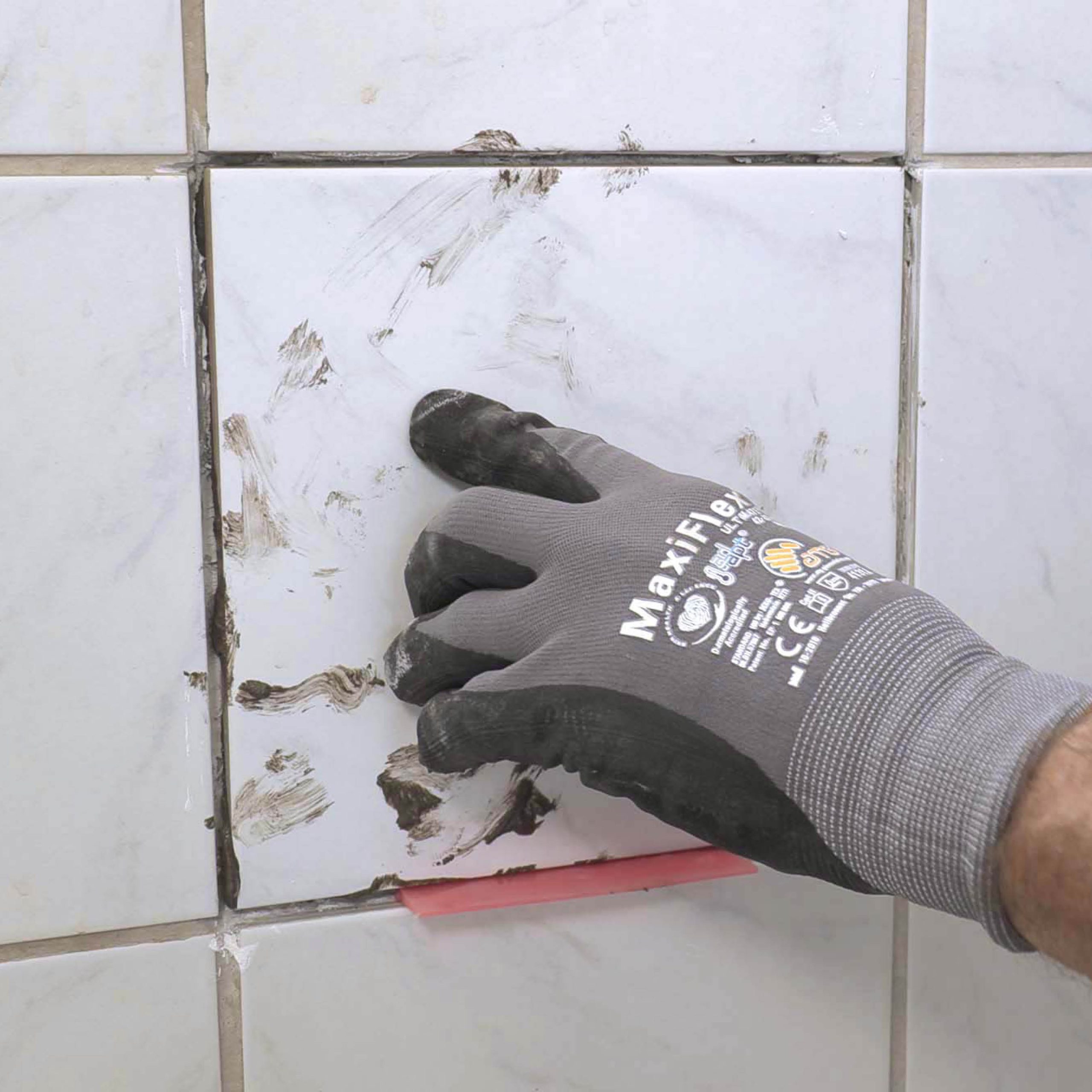 Skade i vægflise: Tryk flisen fast og sæt afstandsbrikker ind i fugen