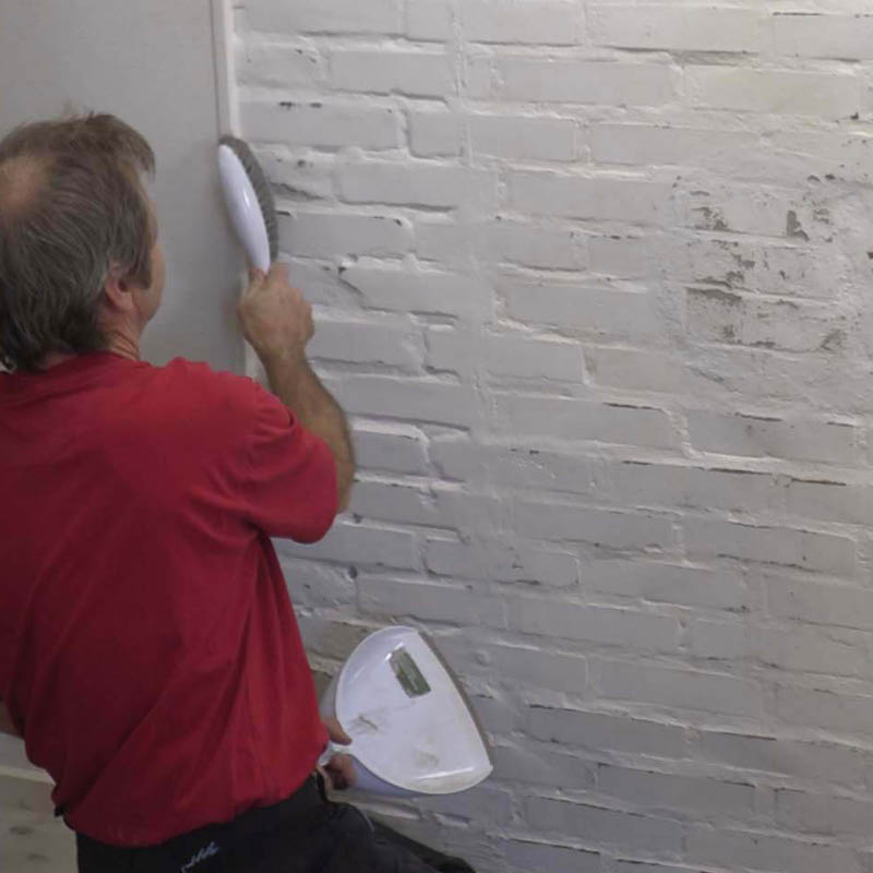 Tiiliseinän tasoitus sisällä: Harjaa hiomapöly pois