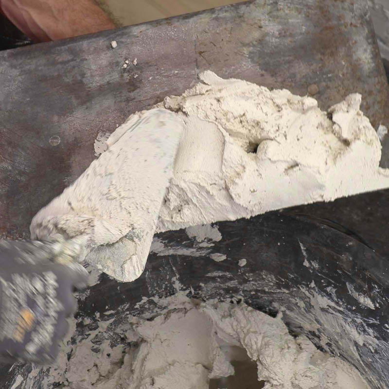 Tiiliseinän tasoitus sisällä: Nosta käsikipsilaastia isolle teräslastalle