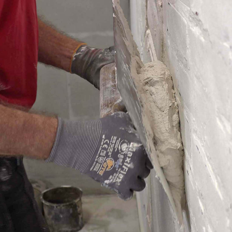 Tiiliseinän tasoitus sisällä: Vedä käsikipsilaasti seinälle