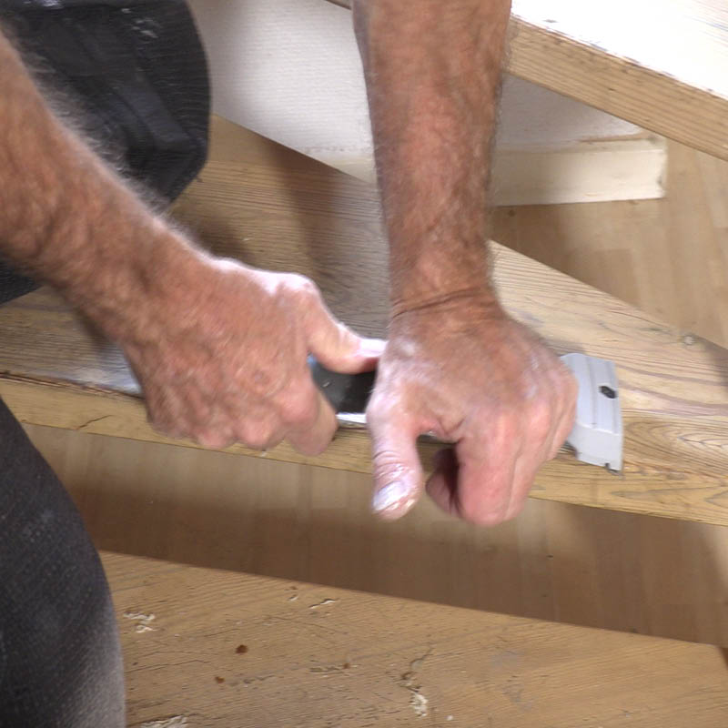 Trappetrinn med nedslitt lakk: Skrap av lakken med et skrapejern