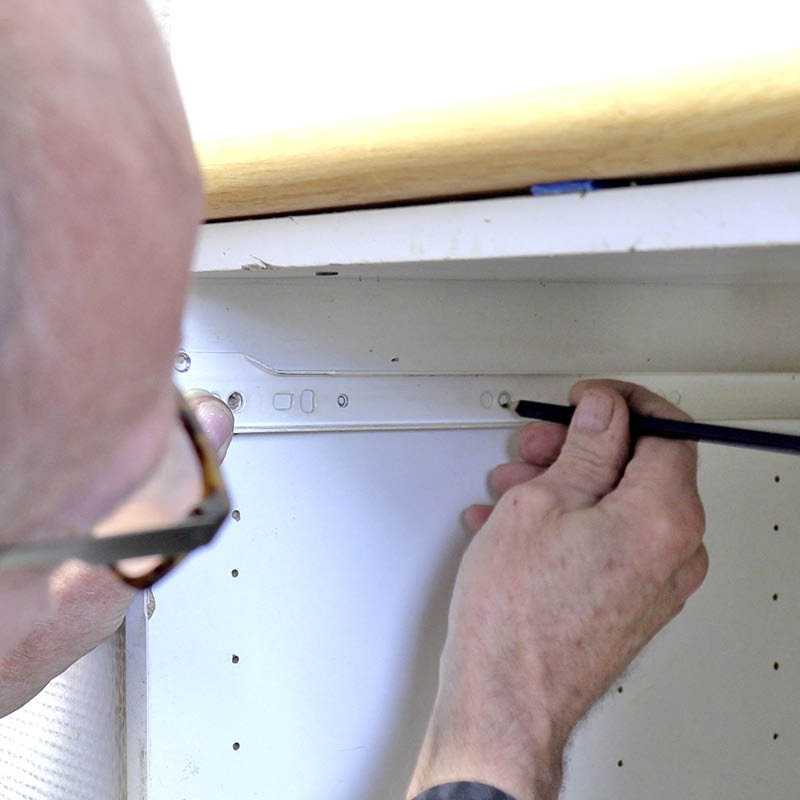 Køkkenskuffen hænger: Mærk op i 2-3 af skinnens ubrugte huller