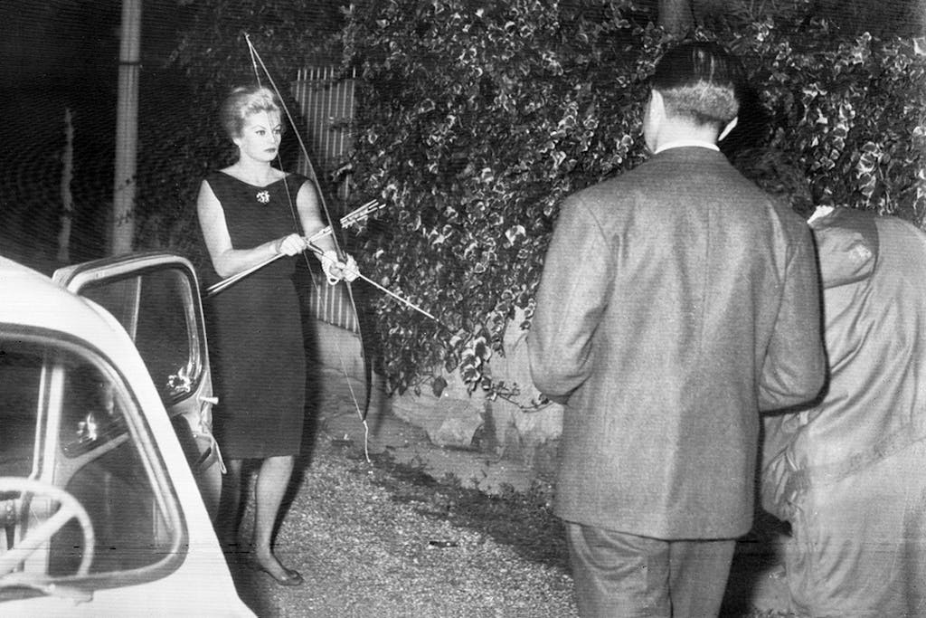 Anita Ekberg spara ai paparazzi con arco e frecce