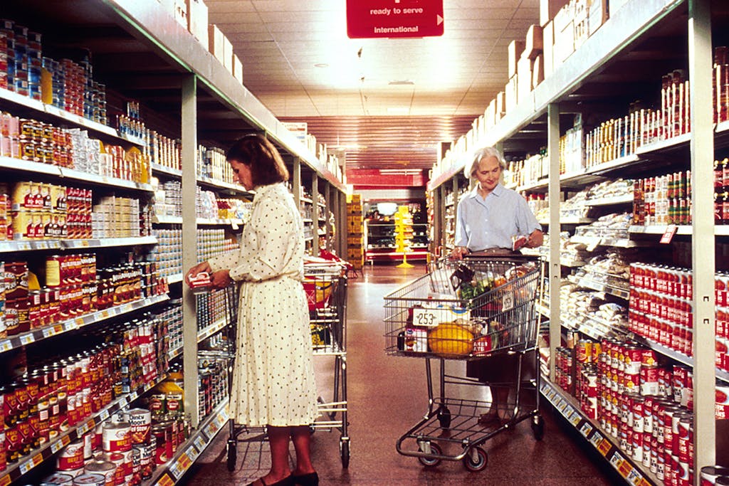 Naisia ostoskärryineen vanhassa supermarketissa Naisia ostoskärryineen vanhassa supermarketissa