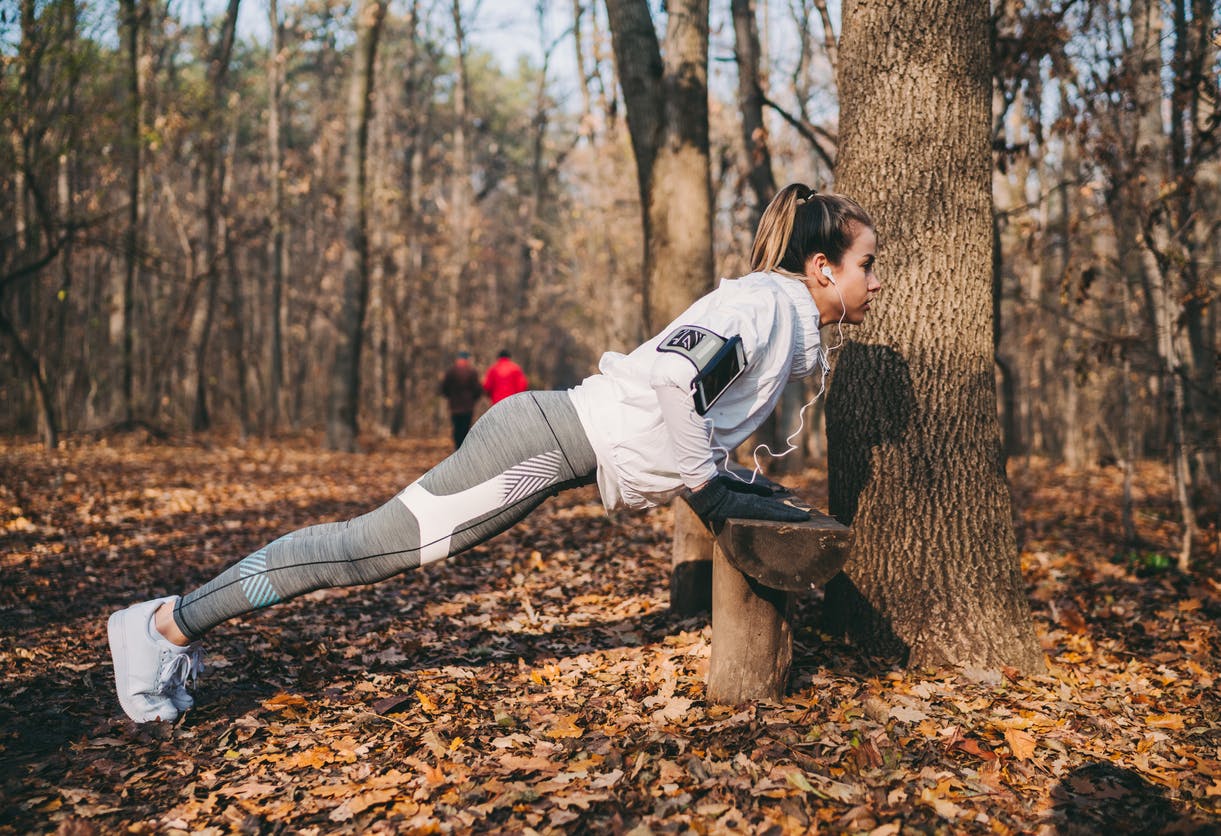 kvinde laver armbøjninger i skov