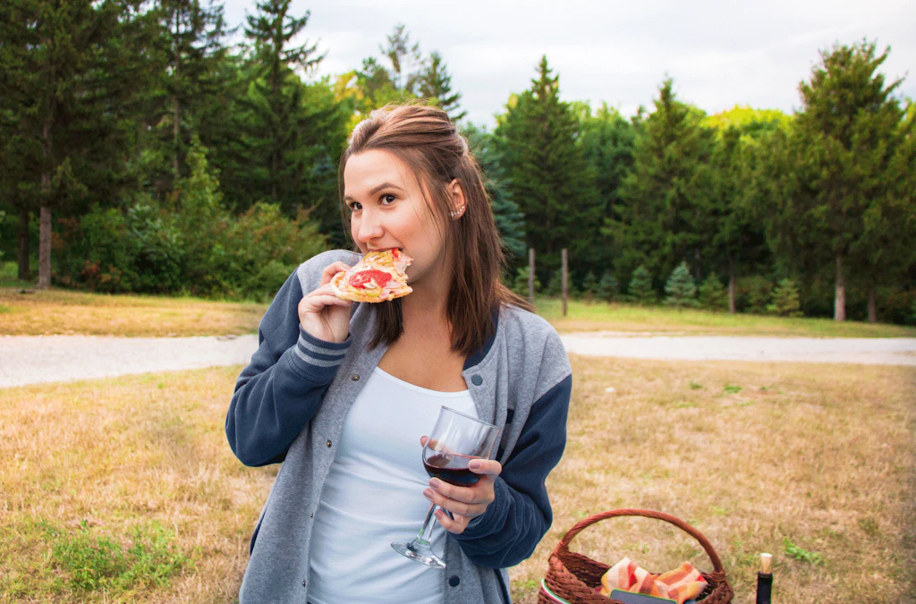 Nainen syö pizzaa ja juo punaviiniä - kaloritaulukko