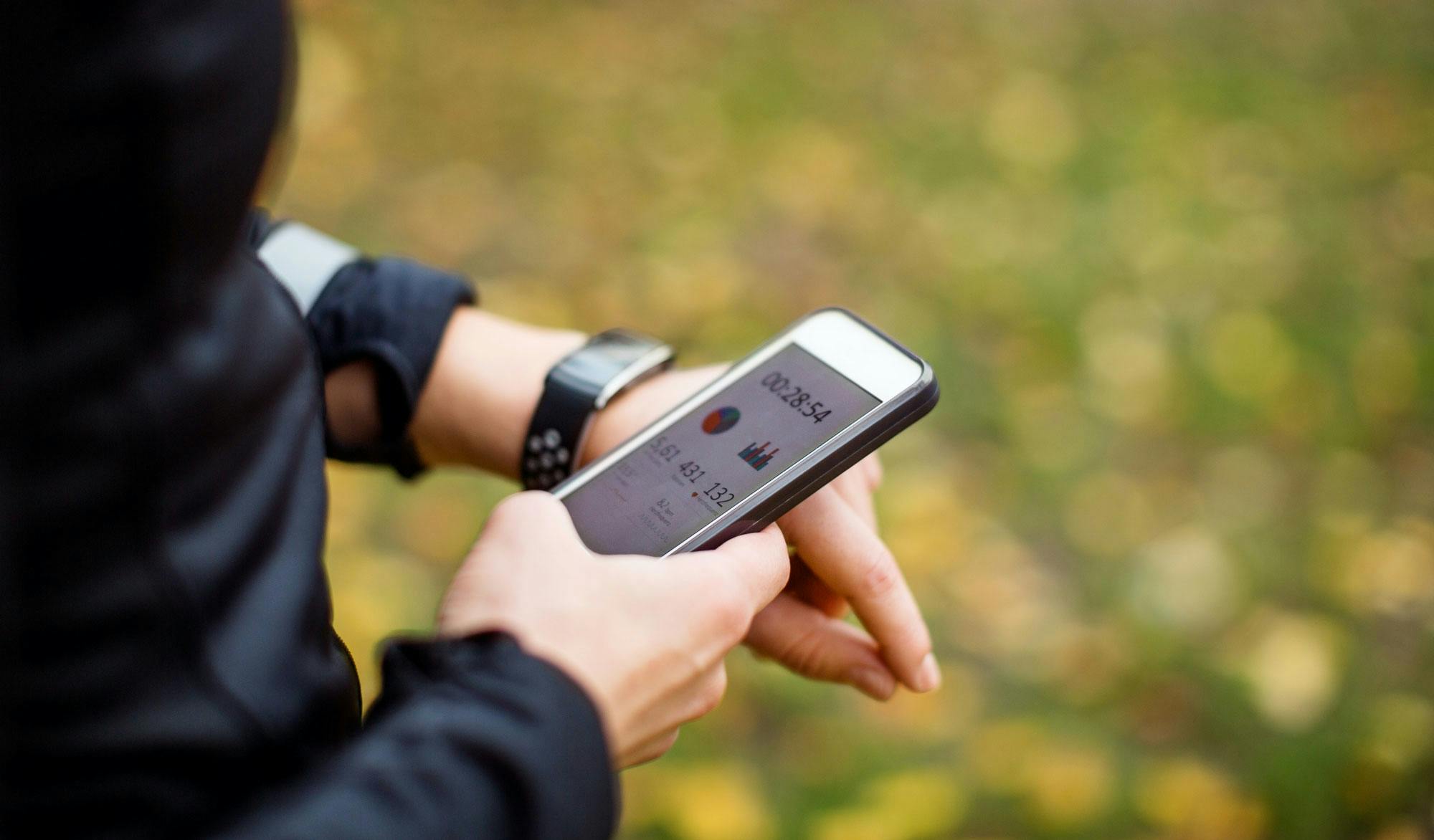 Kvinna med aktivitetsarmband och medföljande mobilapp