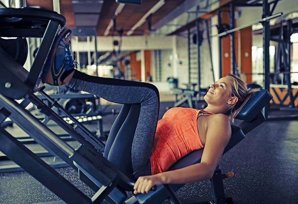 Kvinna som styrketränar i gym – det kan vara riktigt bra vid diskbråck