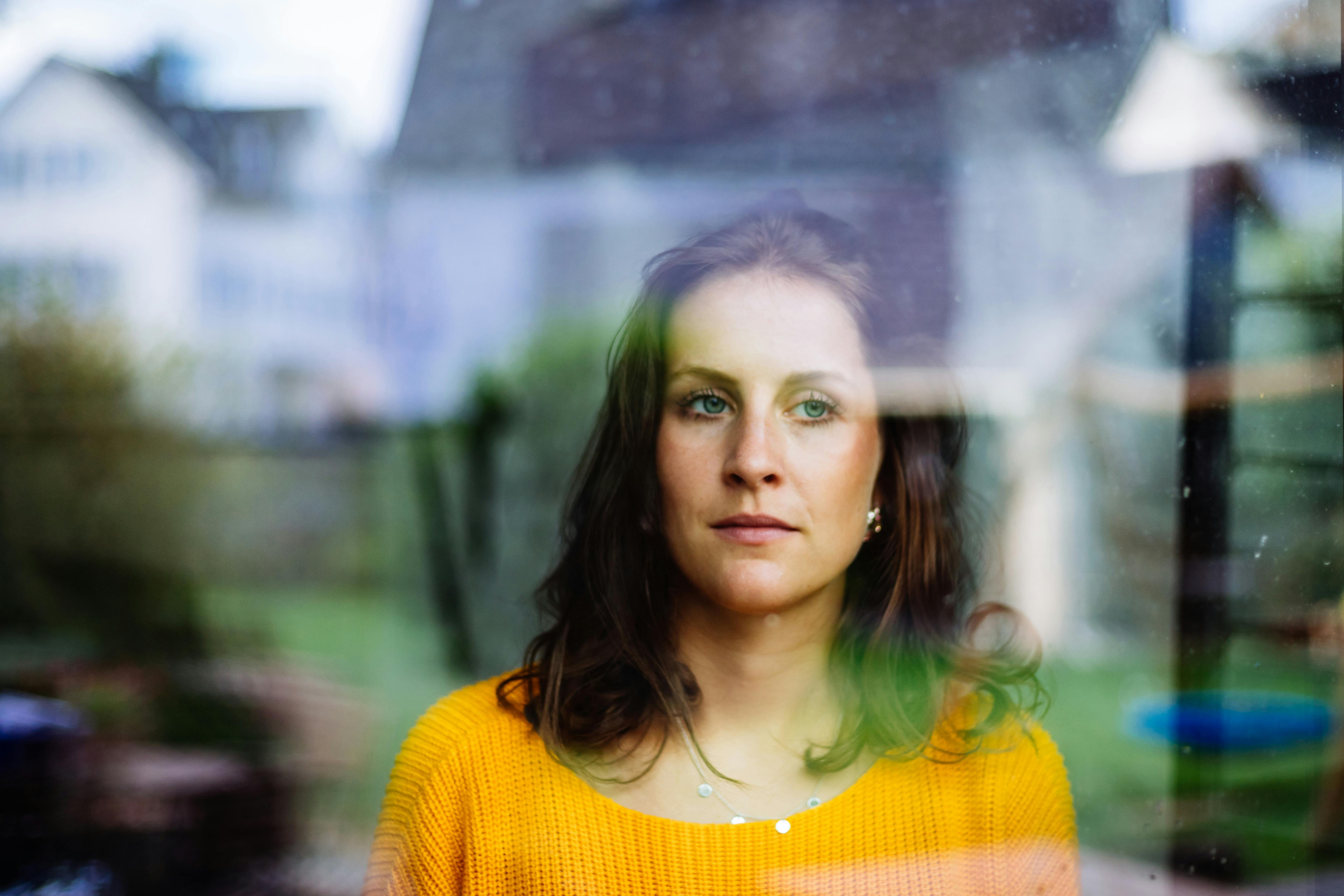 Kvinde kigger ud af vindue