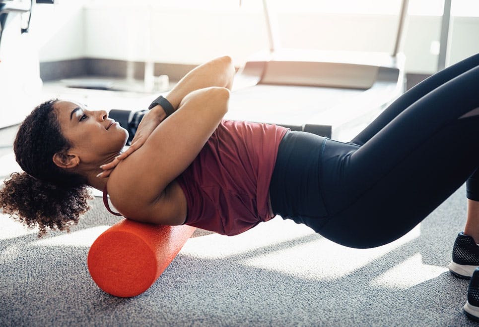 Kvinne gjør ryggøvelse med en foam roller