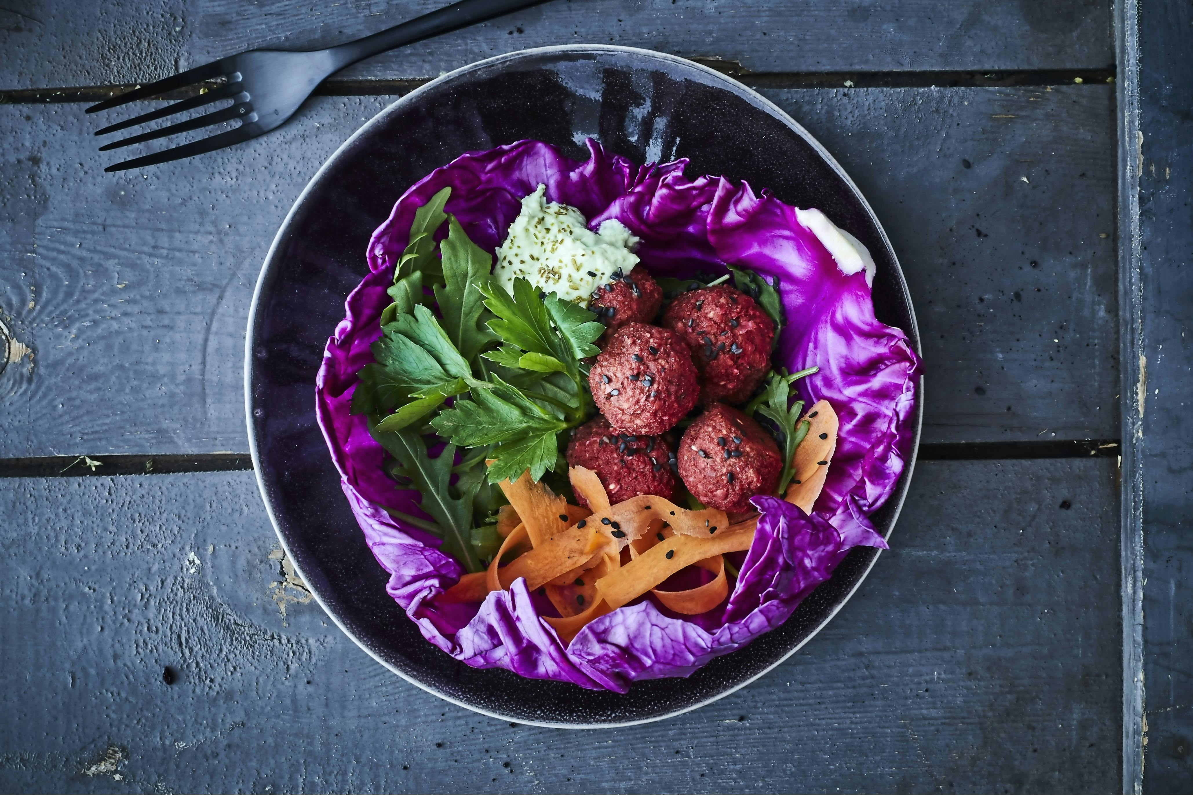 Skål med rödbetsfalafel och grönsaker.