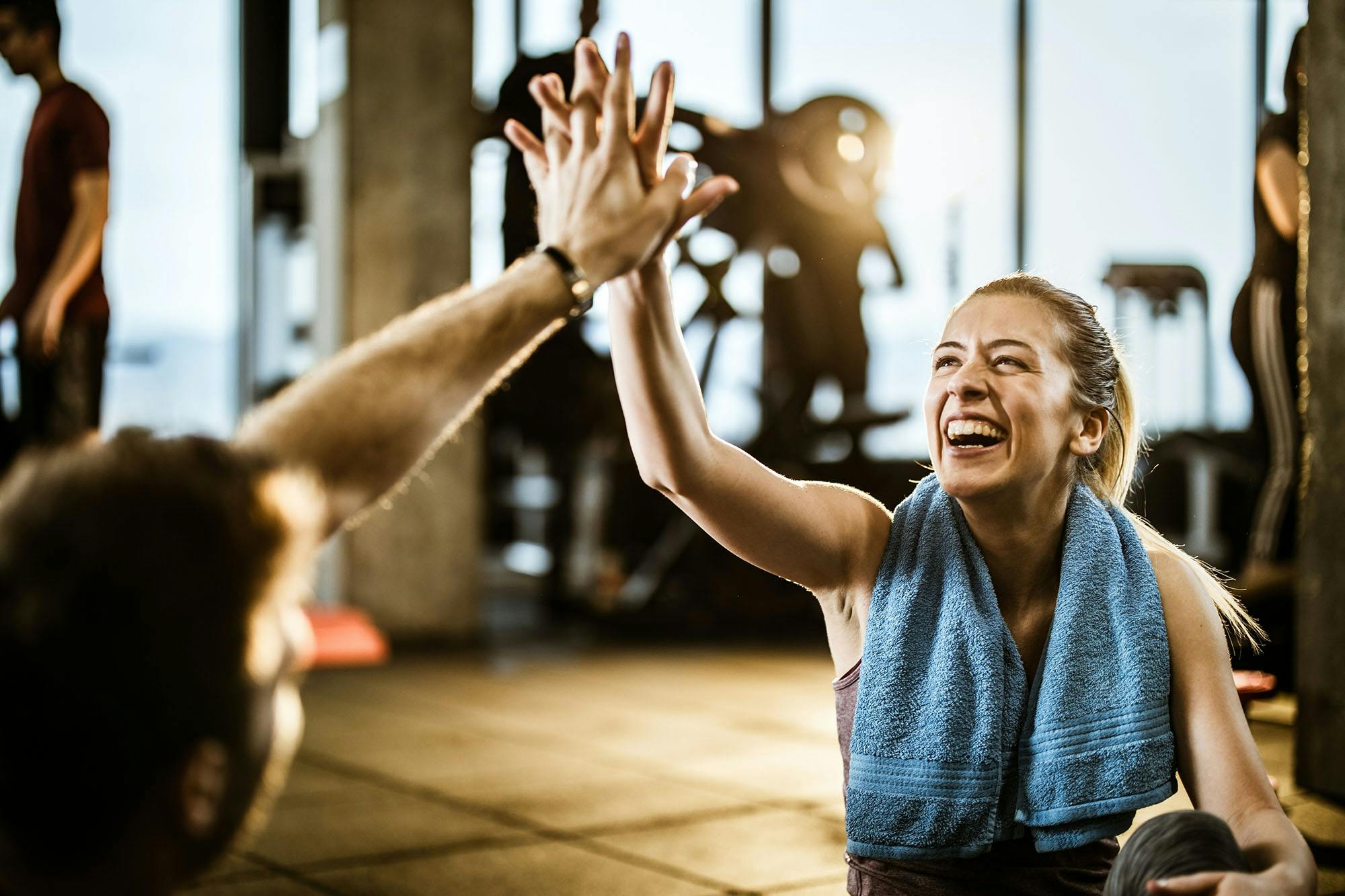 Kvinde og mand highfiver i fitnesscenter. 