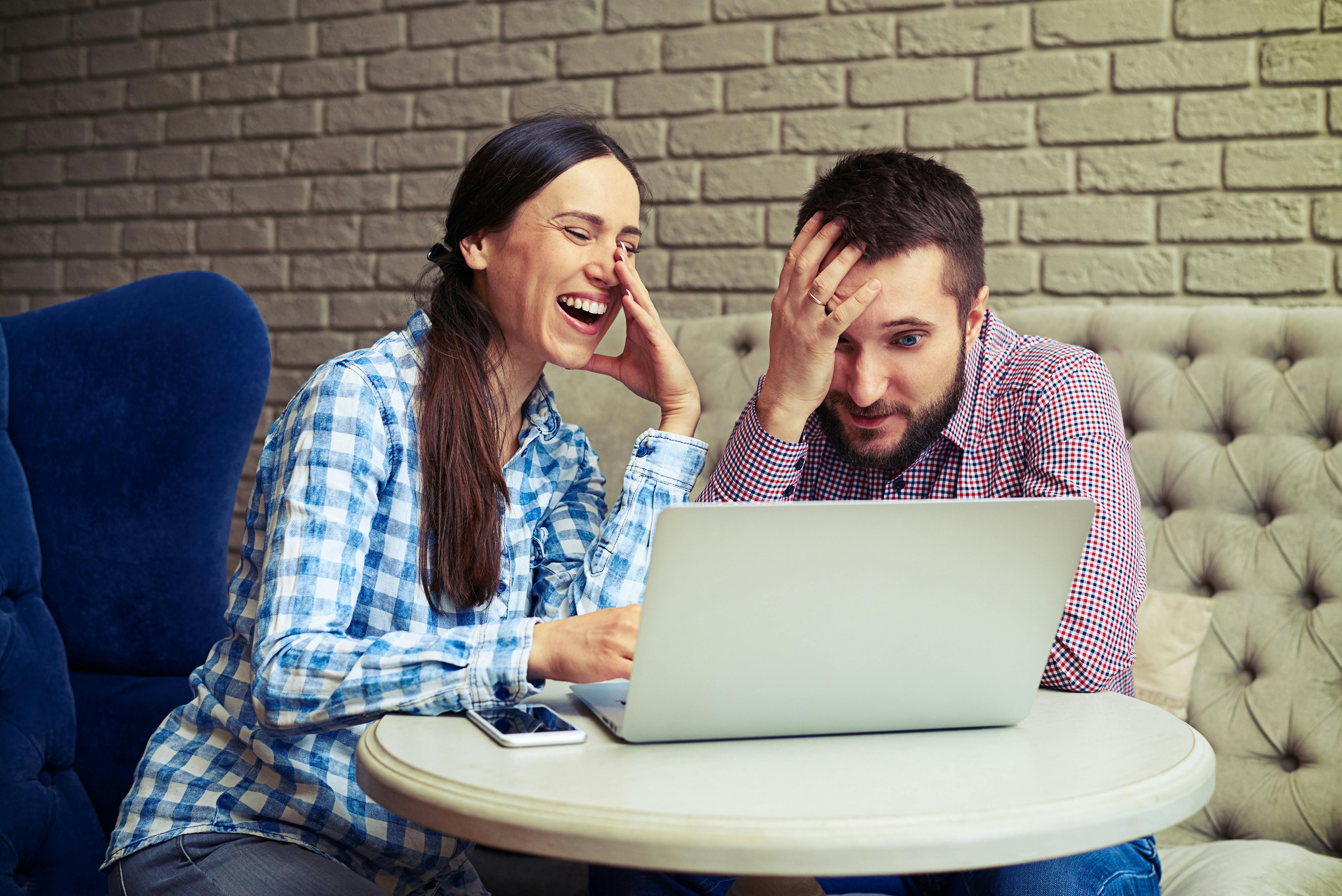Kvinde griner og mand tager sig til hovedet