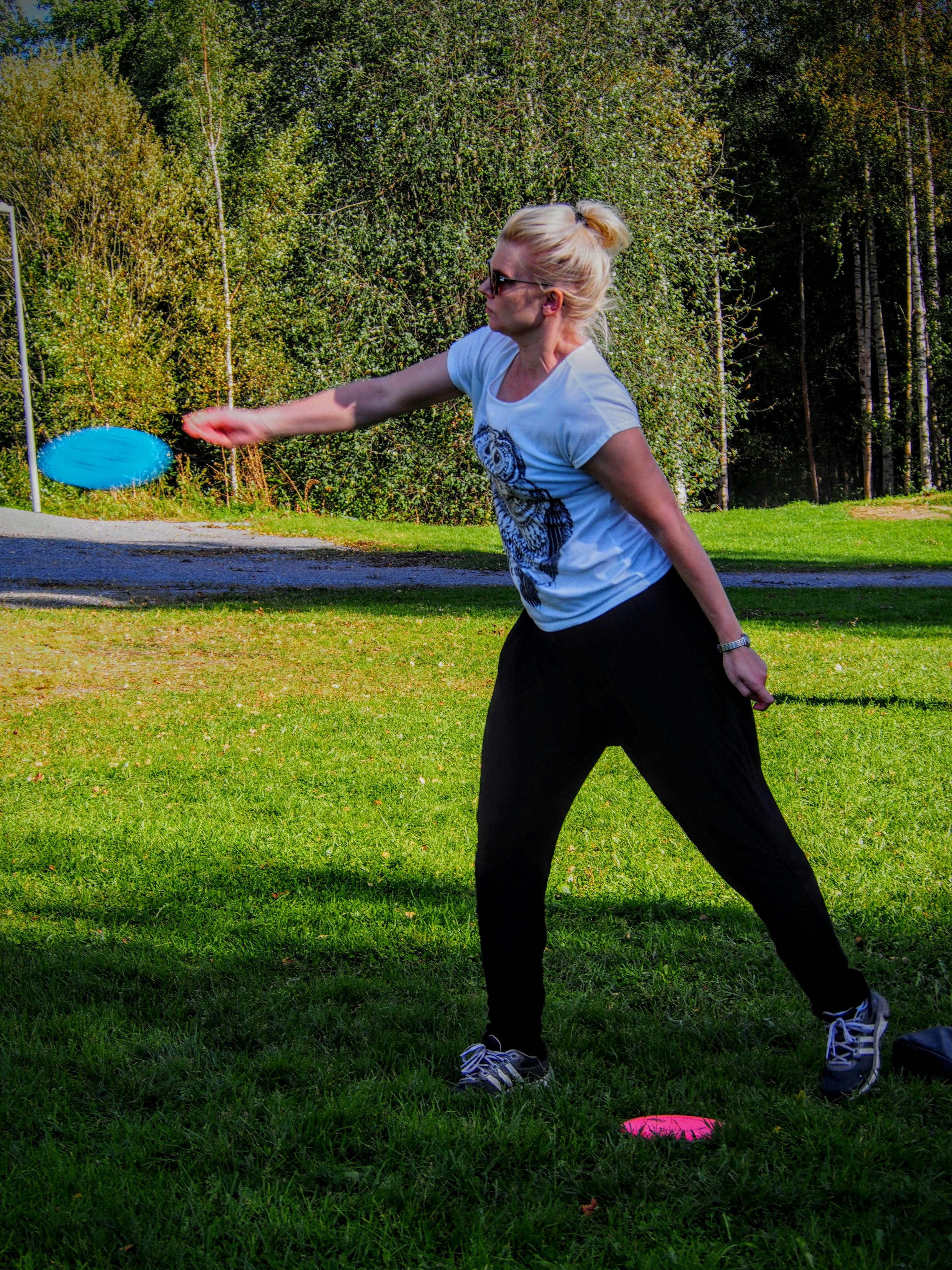 Pia heittää frisbeegolfia