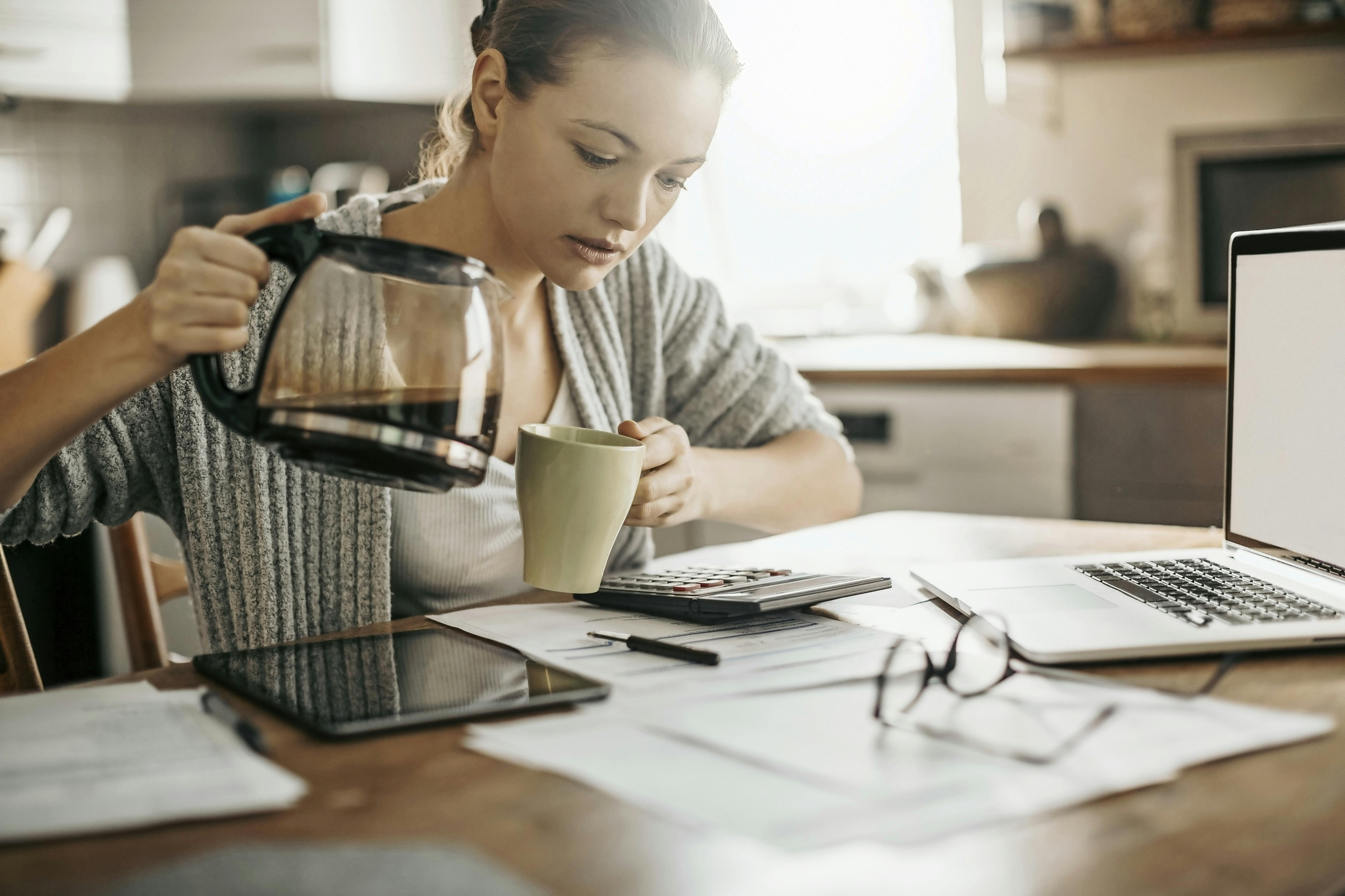 Kvinna häller upp kaffe på jobbet.