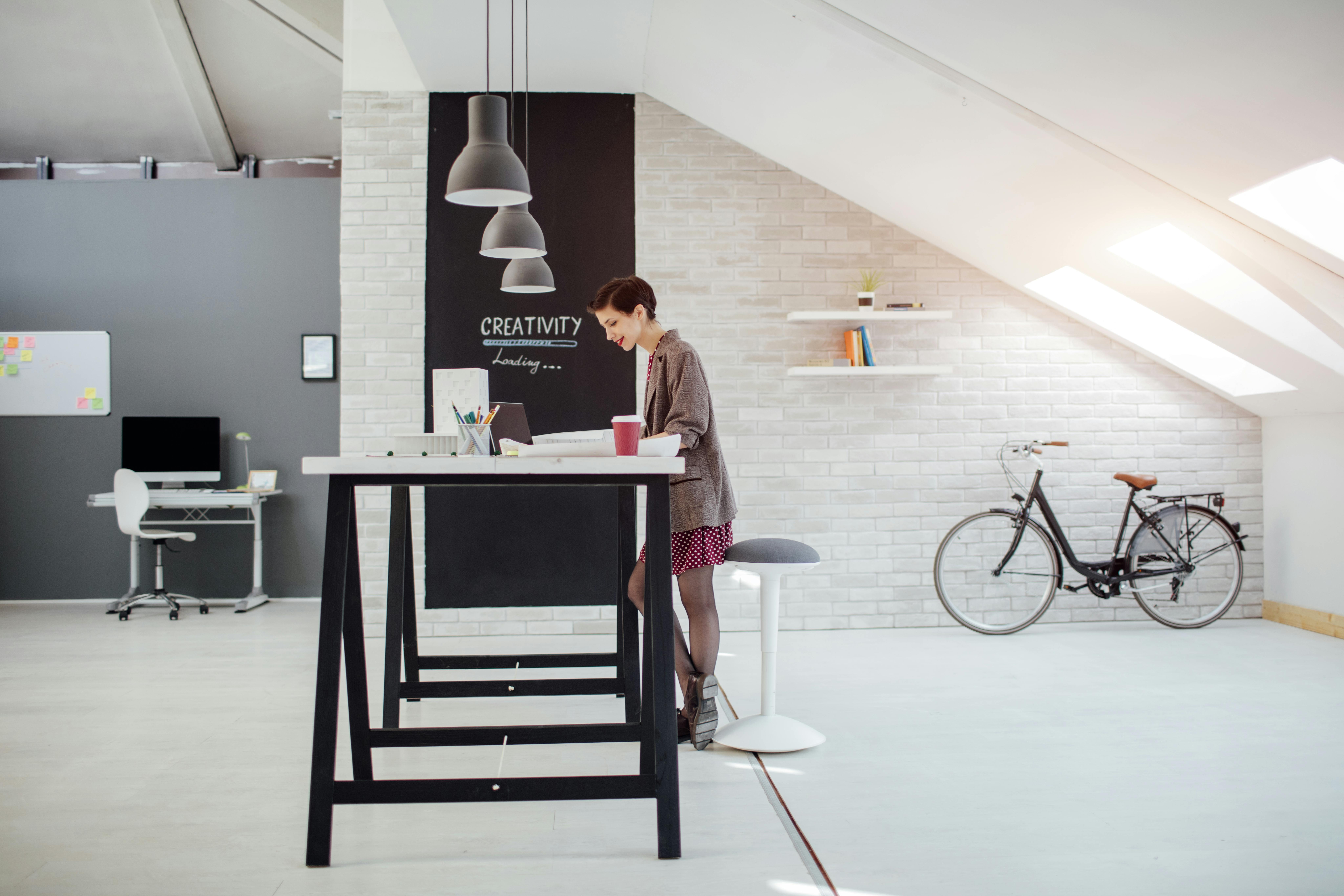 Kvinde står op og arbejder på kontor. 