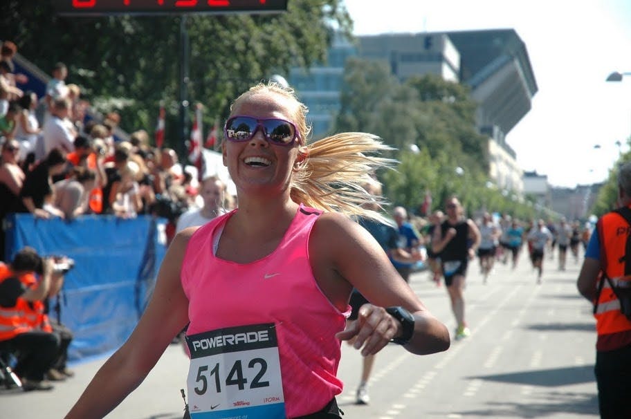 Kvinde løber i mål efter marathon. 