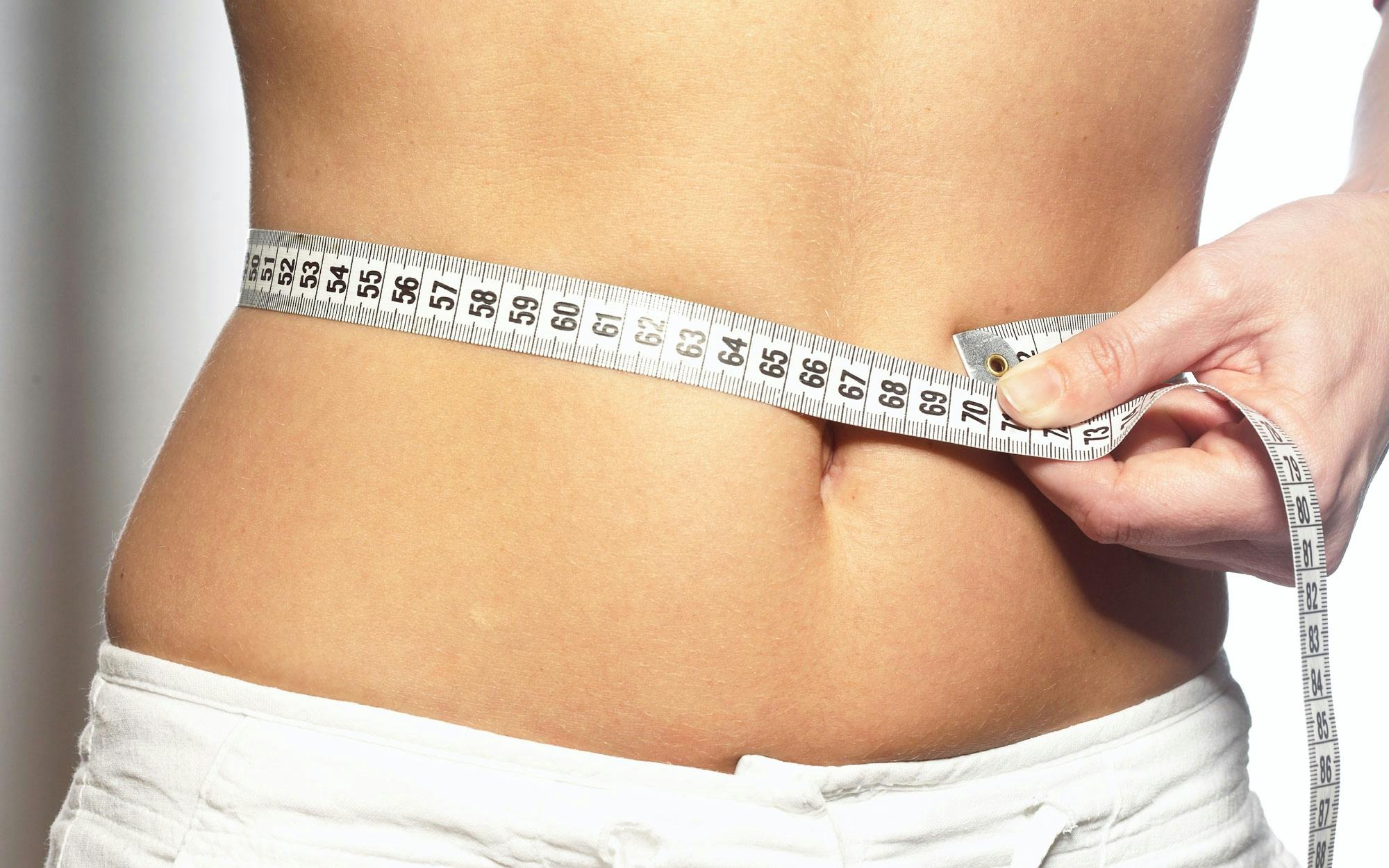 Kvinde måler taljen med målebånd som alternativ til BMI