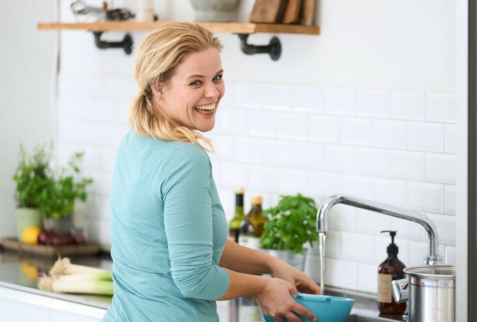 Kvinde laver mad i køkken