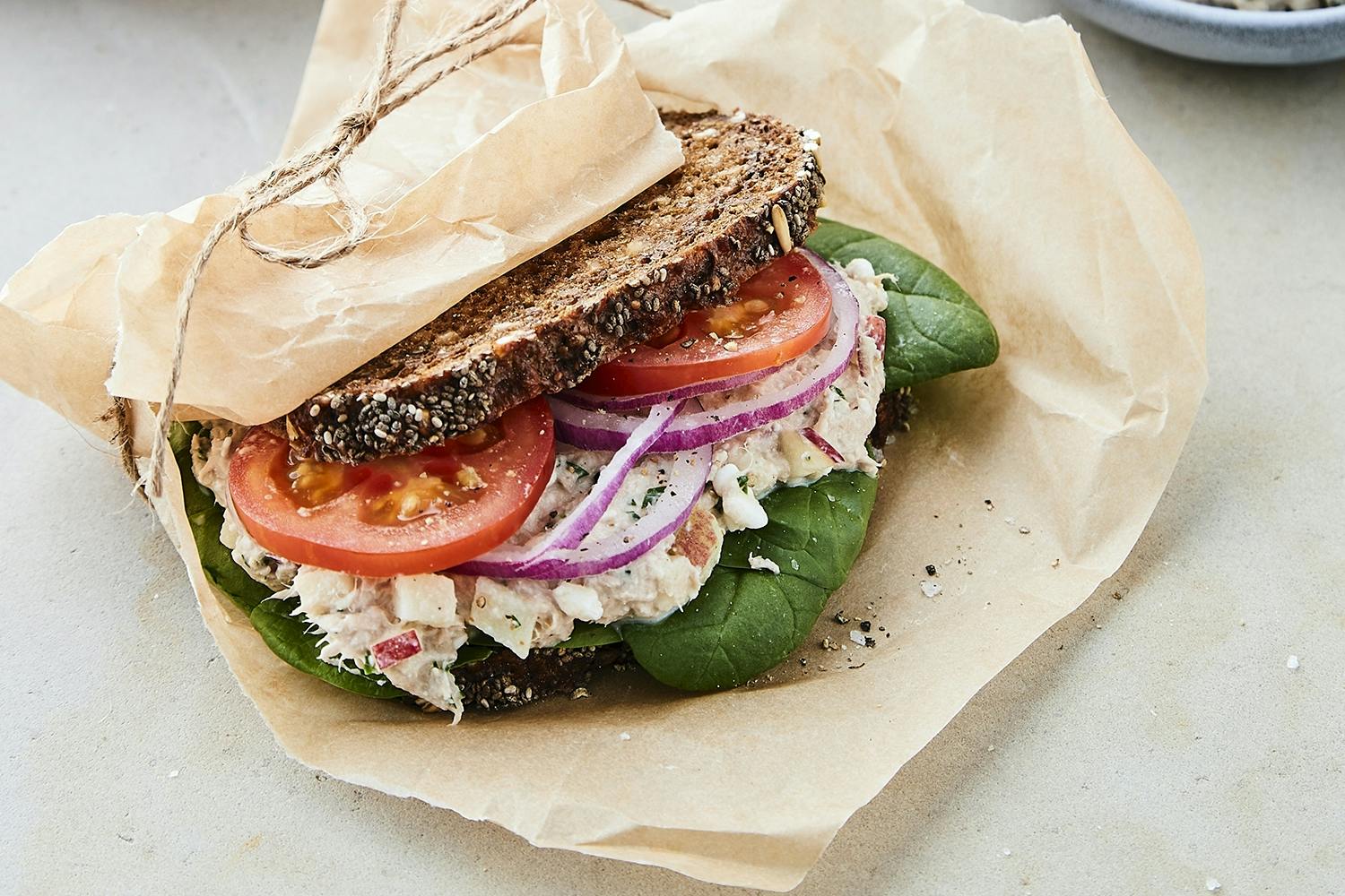 Sandwich av rugbrød med tunfisksalat pakket inn i papir