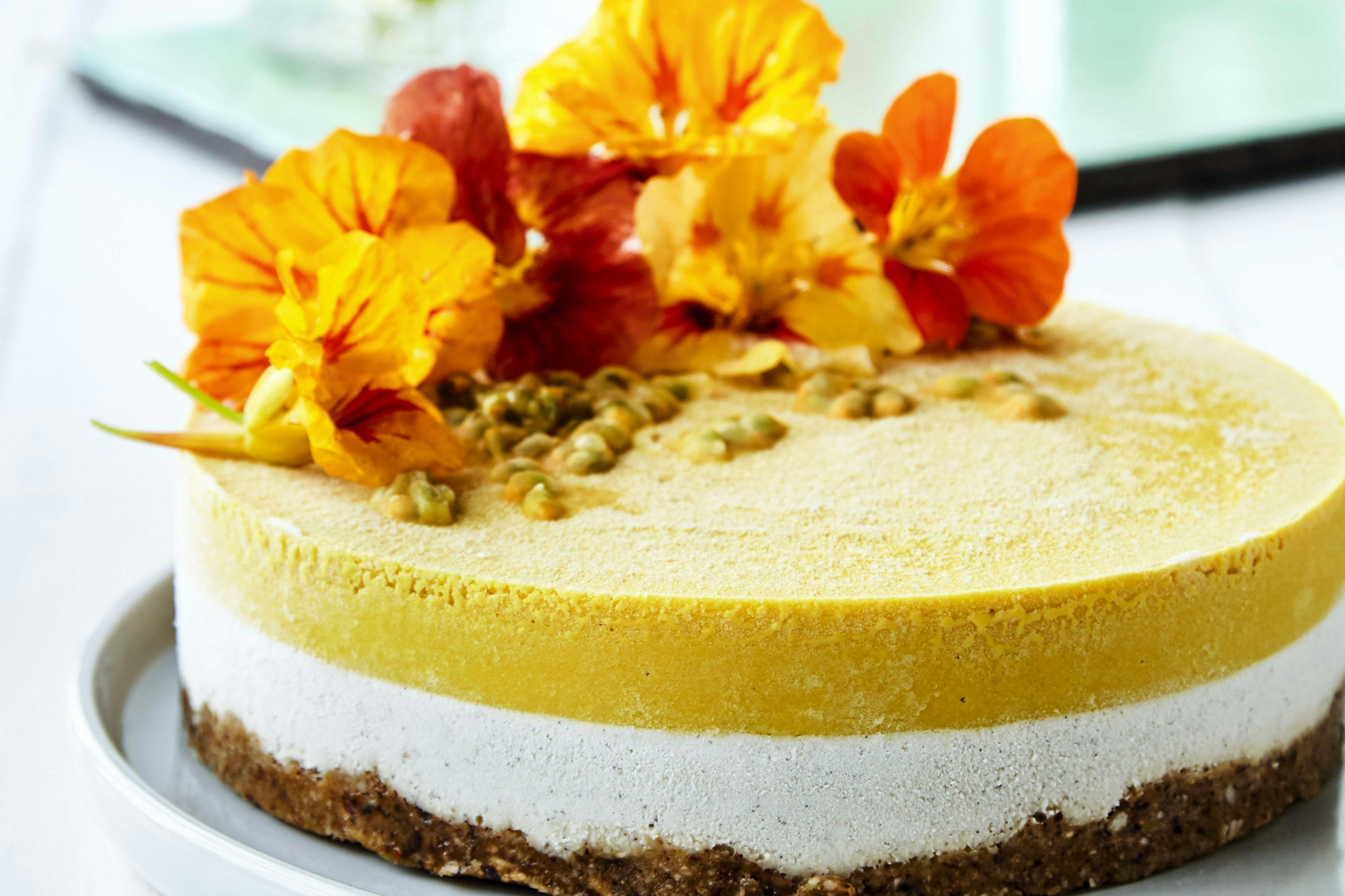 Rawkage med mango, kokos og ingefær og blomster som pynt