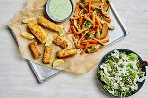 Fat med stekt fisk, morot, potatis och dressing samt skål med sallad av blomkål